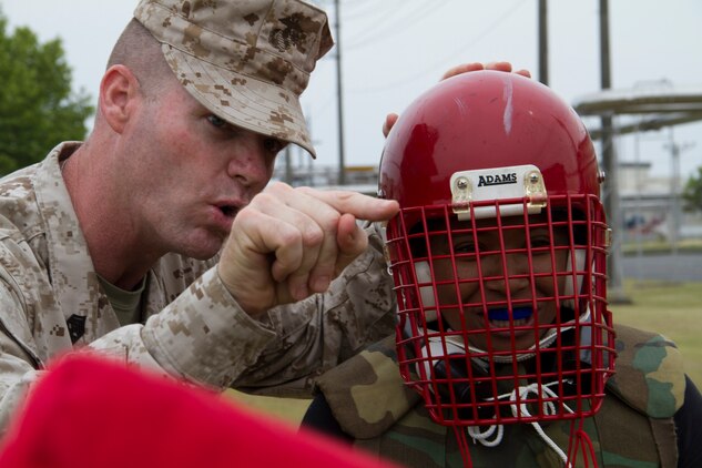 Sgt. Maj. Peter W. Ferral motivates Christiana Sanders, a spouse of a Marine, before her pugil stick bout during Jane Wayne Day aboard Marine Corps Air Station Iwakuni, Japan, May 19. Jane Wayne Day lets family members experience parts of Marine Corps life to provide shared experience and understanding.