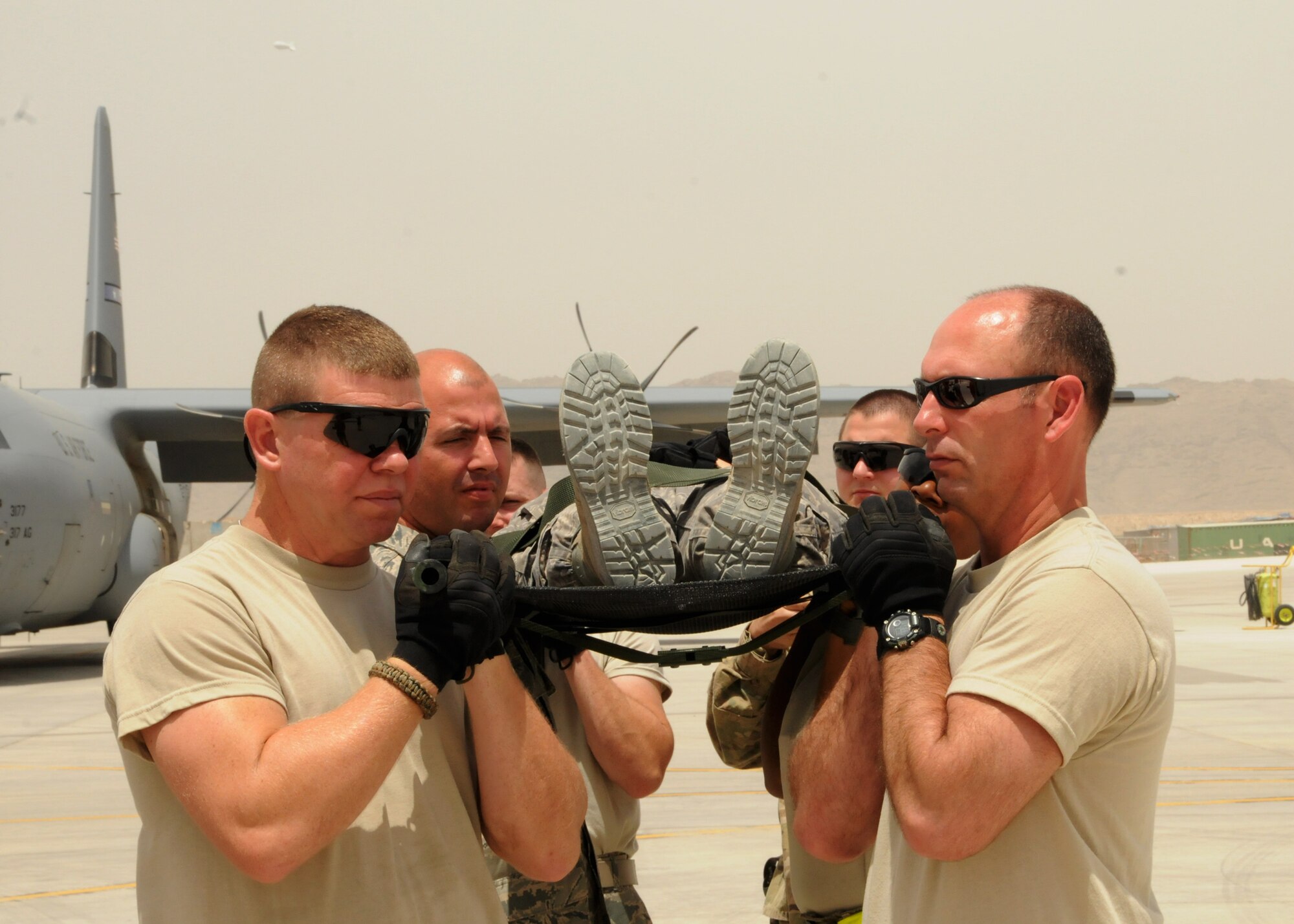 Staff Sgt. Timothy Alewine (Left), 451st Expeditionary Aircraft Maintenance Squadron munitions specialist, and Master Sgt. Michael Stuart (Right), 451st EAMXS aerospace ground equipment craftsman, carry a fellow service member on a litter during a Contingency Aerospace Staging Facility litter training exercise May 5, 2012. The training teaches volunteers proper lifting techniques and how to safely transport wounded warriors from Role 3 and the CASF to a C-130. (U.S. Air Force photo by Staff Sgt. Heather Skinkle)