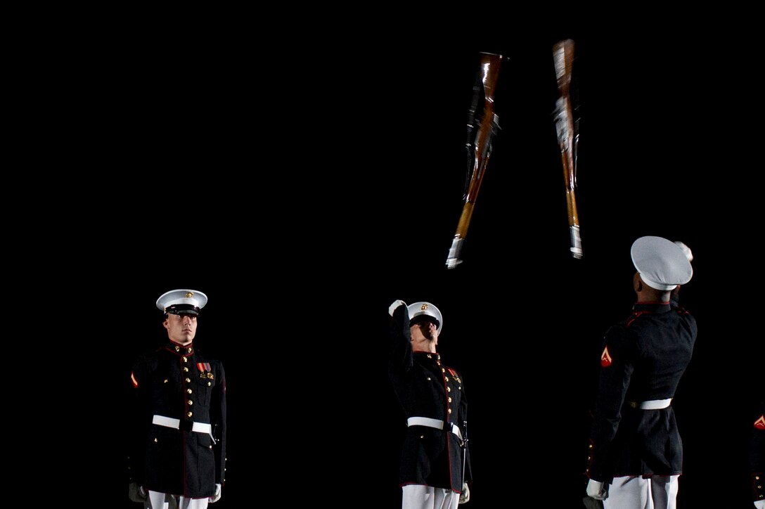Members of the Marine Corps Silent Drill Platoon throw M1 Garand rifles into the air during an evening parade at Marine Barracks Washington May 18, 2012, in Washington D.C.
