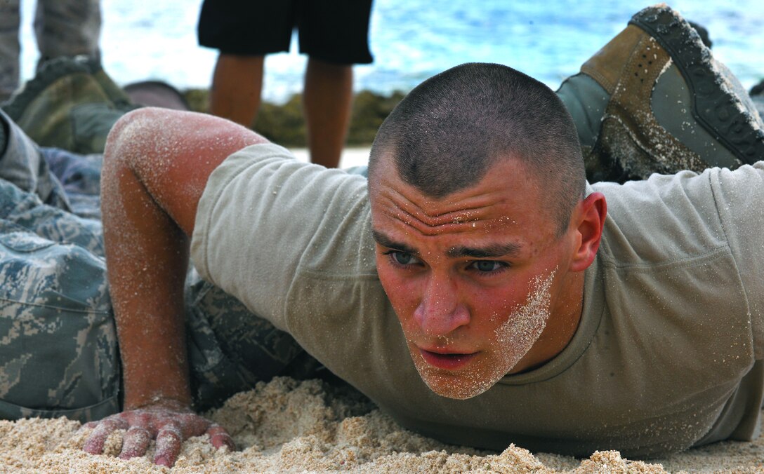 ANDERSEN AIR FORCE BASE, Guam—Airman Cody Rother, 36th Security Forces Squadron, helps his team do fire team push-ups during the “Team Pain” portion of the Warrior Challenge May 16. Andersen held the challenge in support of National Police Week. (U.S. Air Force photo by Senior Airman Benjamin Wiseman/Released)