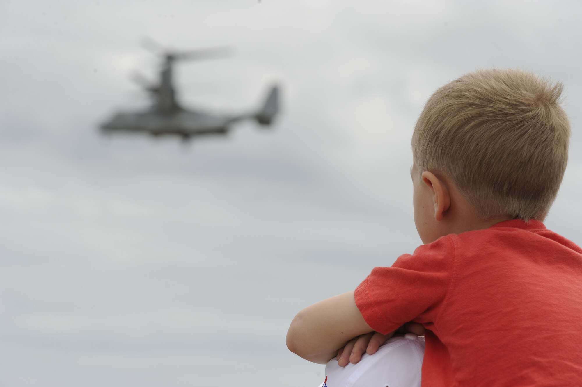 A child looks on at the U.S. Marine Corps V-22 Osprey deminstrating its capabilities at the 2012 Joint Service Open House May 20 on Joint Base Andrews, Md. This year's JSOH celebrates the centennial of Marine Corps Aviation. JSOH affords the public the opportunity to meet the men and women of the Armed Forces while viewing more than 100 static displays and 19 aerial demonstration teams. (U.S. Air Force photo by Staff Sgt. Christopher Ruano)