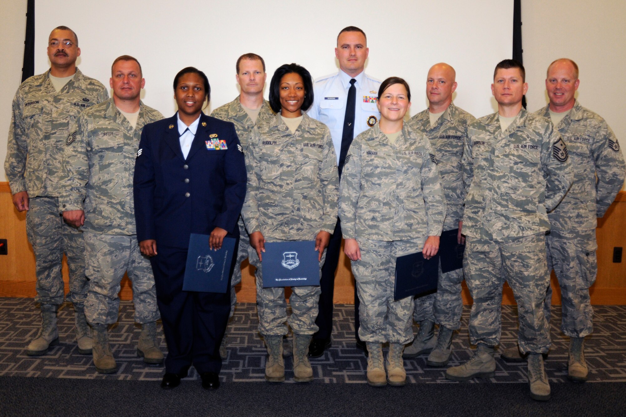 The members of the 2012 Community College of the Air Force graduating class from the 127th Wing at Selfridge Air National Guard Base, Mich., gather after receiving their diplomas during a May 20, 2012, ceremony. The CCAF provides an avenue for Airmen to gain credit for their formal military technical training. (U.S. Air Force photo by TSgt. David Kujawa)