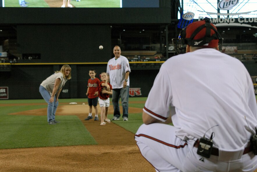 Alanna Aguirre, 5, throws the first pitch to her dad, Lt. Col. Paul Aguirre during the May 7, 2012, Diamondbacks game against the St. Louis Cardinals. Alanna and her brother, Jackson, 6, did not know their dad was posing as a Diamondbacks catcher. Colonel Aguirre traveled for three days following a seven-month deployment to Afghanistan to surprise his children in a homecoming event they will never forget. (U.S. Air Force photo by Staff Sgt. Daryl Gladstein/Released)