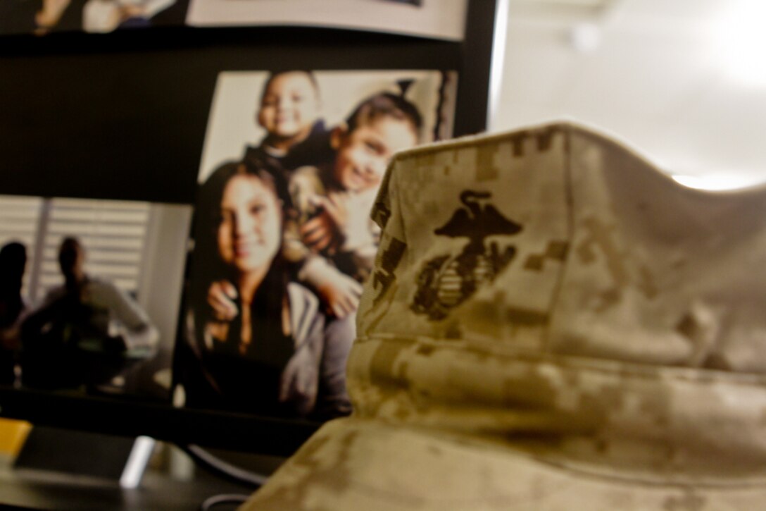 A Marine Corps eight-point cover lays next to family photos, showcasing Staff Sgt. Maribel Valdez's balancing act between her family and her military career, May 15, 2012. She is the adjutant with 1st Marine Division (Forward). Valdez said she knows it's difficult for her family while she's deployed but plans on spending a lot of time with her family when she returns home.::r::::n::::r::::n::::r::::n::::r::::n::::r::::n::