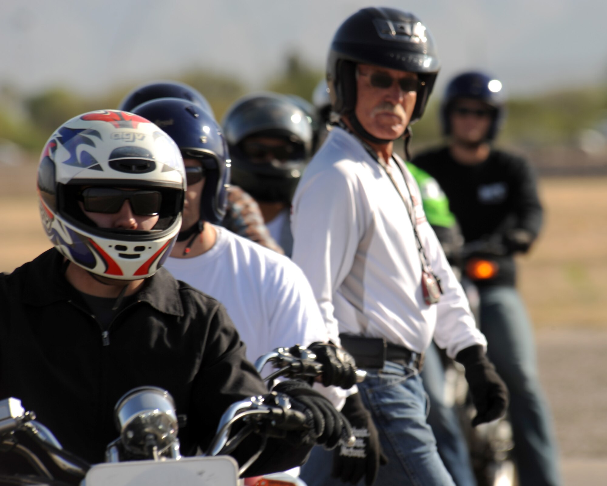 Students of the Motorcycle Safety Basic Rider Course wait in line as Chris Life, motorcycle safety instructor, walks to get in place to monitor the riders on Davis-Monthan Air Force Base, Ariz., May 8, 2012. The course is taught in several locations in Ariz. The D-M location is specifically for military members, their dependants, and civilian Department of Defense employees. (U.S. Air Force photo by Airman 1st Class Timothy D. Moore/Released)