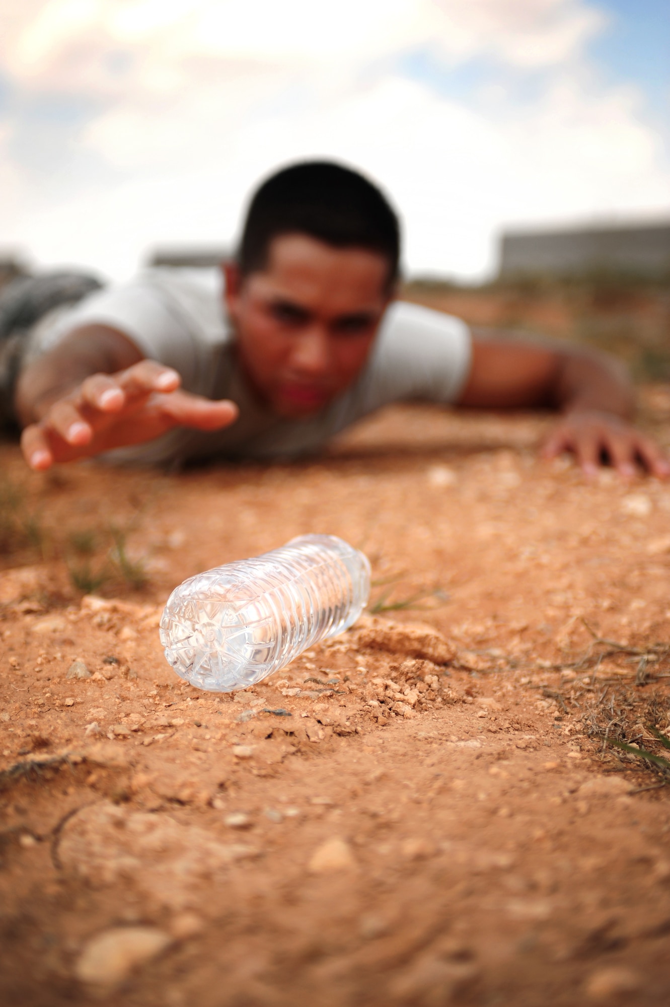 U.S. Air Force Airman 1st Class Alexxis Pons Abascal, 27th Special Operations Wing Public Affairs, struggles across barren terrain to reach his water source at Cannon Air Force Base, N.M., May 21, 2012. Hydration is critical in overall wellness and performance, and is one of the most misunderstood heath concerns. (U.S. Air Force photo by Airman 1st Class Eboni Reece)  