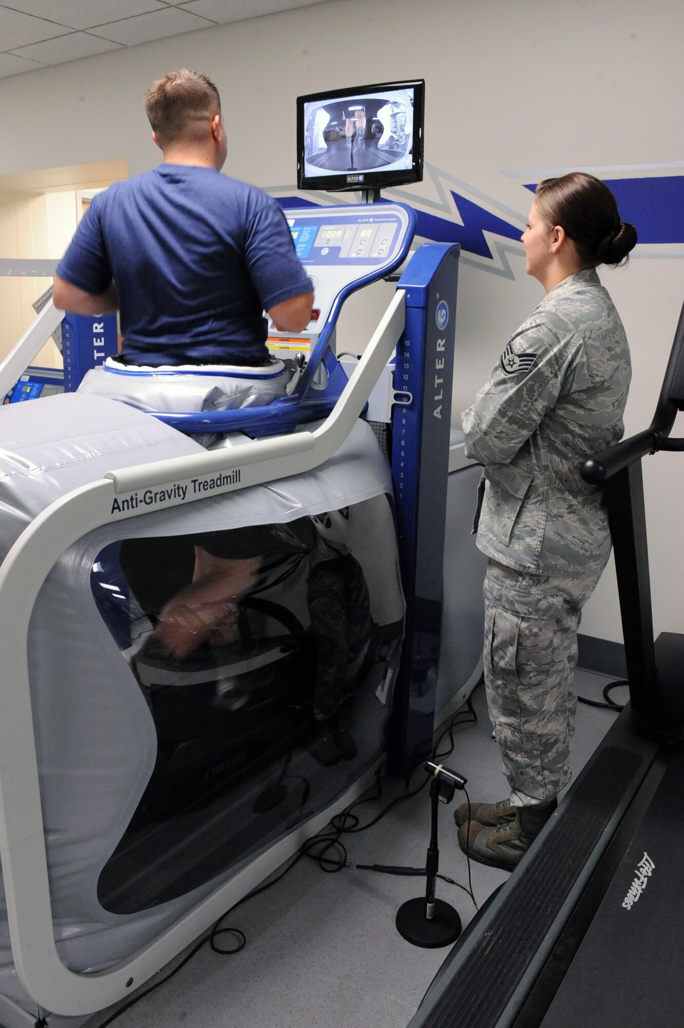 U.S. Air Force Staff Sgt. Amanda Beard, 355th Medical Operations Squadron, watches Staff Sgt. Andrew Kelp, 355th Equipment Maintenance Squadron, as he works on his running on the Alter G treadmill at the Physical Therapy Clinic on Davis-Monthan Air Force Base, Ariz., May 16, 2012. The Alter G treadmill provides reduced stress on joints, increase distance, maintain aerobic fitness while injured and perform workouts and a faster pace. (U.S. Air Force photo by Airman 1st Class Christine Griffiths/Released) 