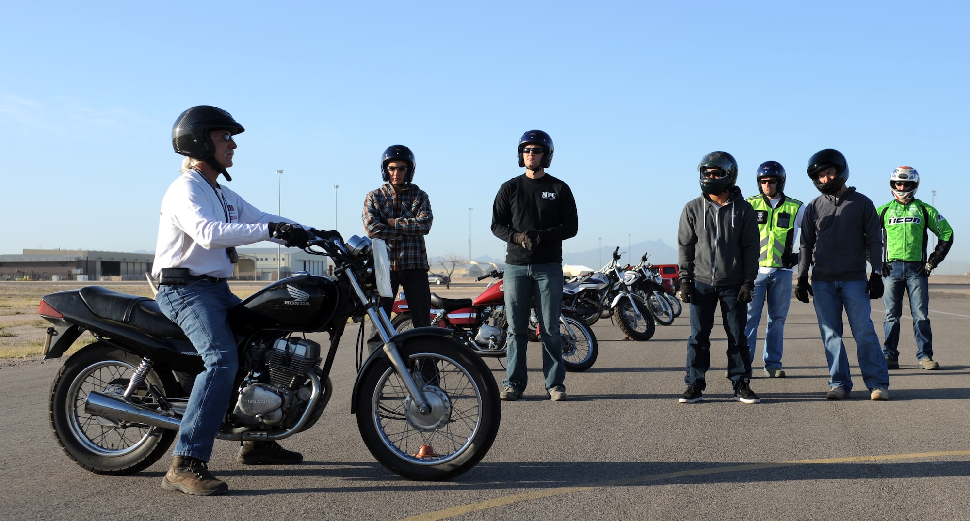 Chris Life, motorcycle safety instructor, demonstrates proper riding procedures to the students of the Motorcycle Safety Basic Rider Course on Davis-Monthan Air Force Base, Ariz., May 8, 2012. The course teaches student everything from mounting and dismounting a motorcycle to emergency braking. (U.S. Air Force photo by Airman 1st Class Timothy D. Moore/Released)