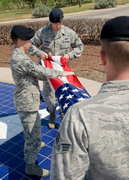 Airmen from the 7th Security Forces Squadron fold the flag during a retreat ceremony May 18, 2012, at Dyess Air Force Base, Texas. As part of Police Week, a retreat ceremony was held in remembrance of nine members of the squadron who passed away in the line of duty. (U.S. Air Force photo by Airman 1st Class Peter Thompson/ Released)