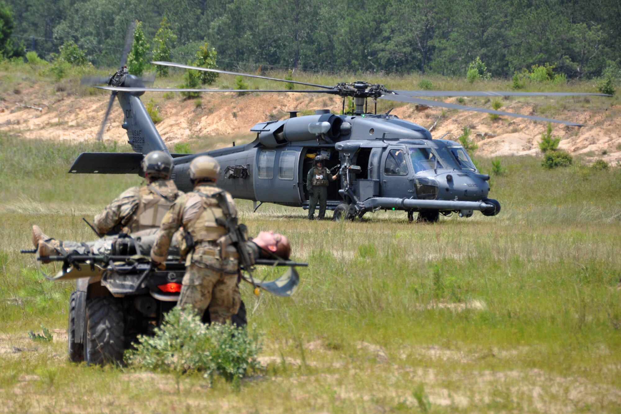 Pararescuemen assigned to the 920th Rescue Wing from Patrick Air Force Base, Fla., transport an injured patient to a waiting helicopter during the mass casualty phase of the Patriot Saint exercise at Fort Polk, La., May 17, 2012. The goal of the exercise was to challenge pararescuemen to successfully execute combat search and rescue (CSAR) missions in real time while tactically solving enroute, fuel, communication, and OPFOR (Opposing Force) hurdles. (U.S. Air Force photo by Master Sgt. Jeff Walston/Released)