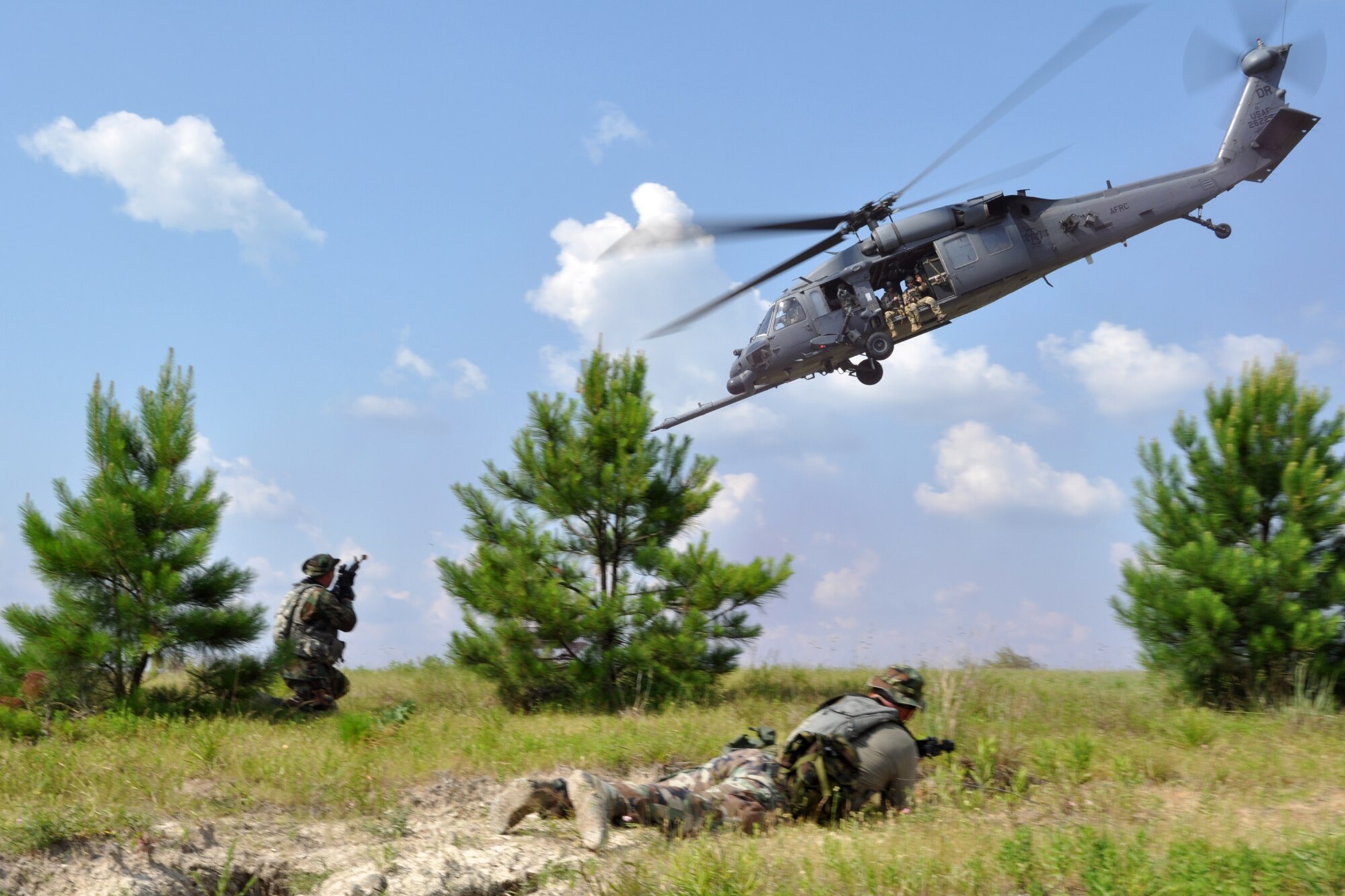 OPFOR (Opposing Force) unit members make a final attack on an HH-60 helicopter as it extracts a group of pararescuemen from the 929th Rescue Wing off the battlefield at Fort Polk, La., May 16, 2012. The Airmen were part of a combat search and rescue (CSAR) mission to rescue two downed pilots during the Patriot Saint exercise. (U.S. Air Force photo by Master Sgt. Jeff Walston/Released)