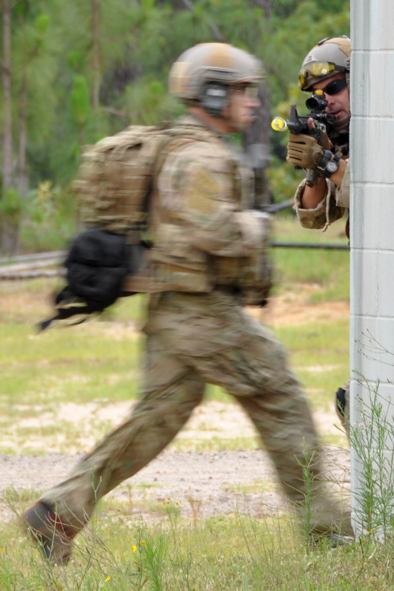 A pararescueman from the 308th Rescue Squadron, Patrick Air Force Base, Fla., covers his team members as they run for cover at the Fort Polk Combined Arms Training Facility City Complex at Fort Polk La., May 15, 2012. The Airmen were part of a combat search and rescue (CSAR) mission to rescue a soldier from hostile forces in support of the Patriot Saint exercise. (U.S. Air Force photo by Master Sgt. Jeff Walston/Released)