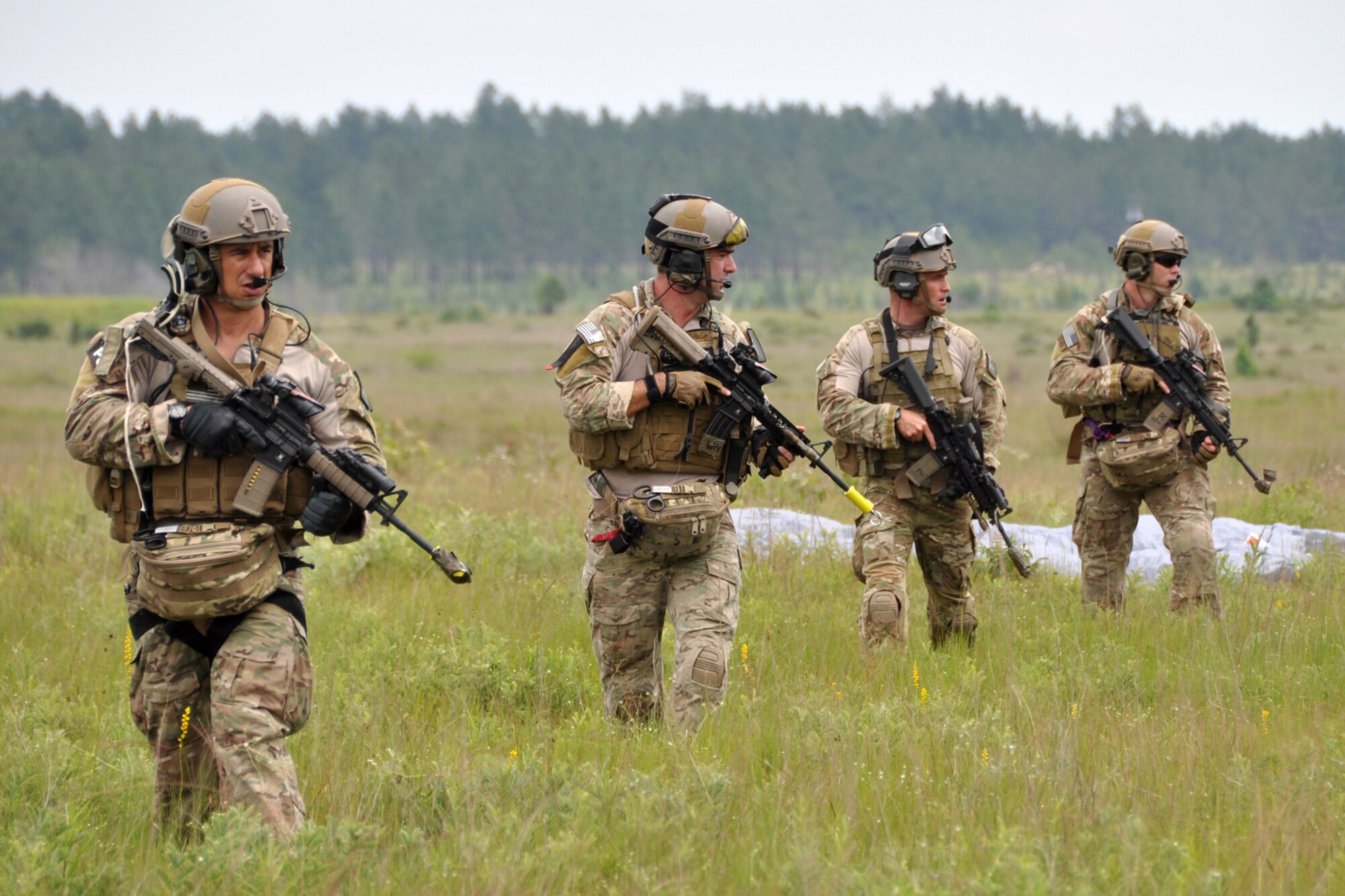 After parachuting into landing zone Berry at Fort Polk, La., pararescuemen from the 308th Rescue Squadron, Patrick Air Force Base, Fla., move to secure the landing zone before HH-60 helicopters infiltrate the remainder of their 10-man team May 15, 2012. The Airmen were part of a combat search and rescue (CSAR) mission to rescue a soldier from hostile forces in support of the Patriot Saint exercise. (U.S. Air Force photo by Master Sgt. Jeff Walston/Released)