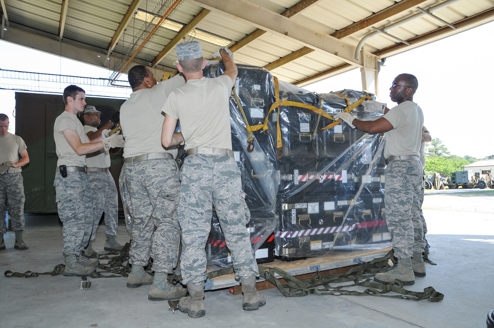 National Guard Airmen from the 117th Air Control Squadron place netting on an equipment pallet at Hunter Army Airfield in Savannah, GA, April 21, 2012. The 117th ACS is the first unit in the U.S. Air Force or Air National Guard to reduce the transportation footprint by using pallets instead of convoy vehicles to move an Air Control Squadron. (National Guard photo by Tech. Sgt. Charles Delano/Released)