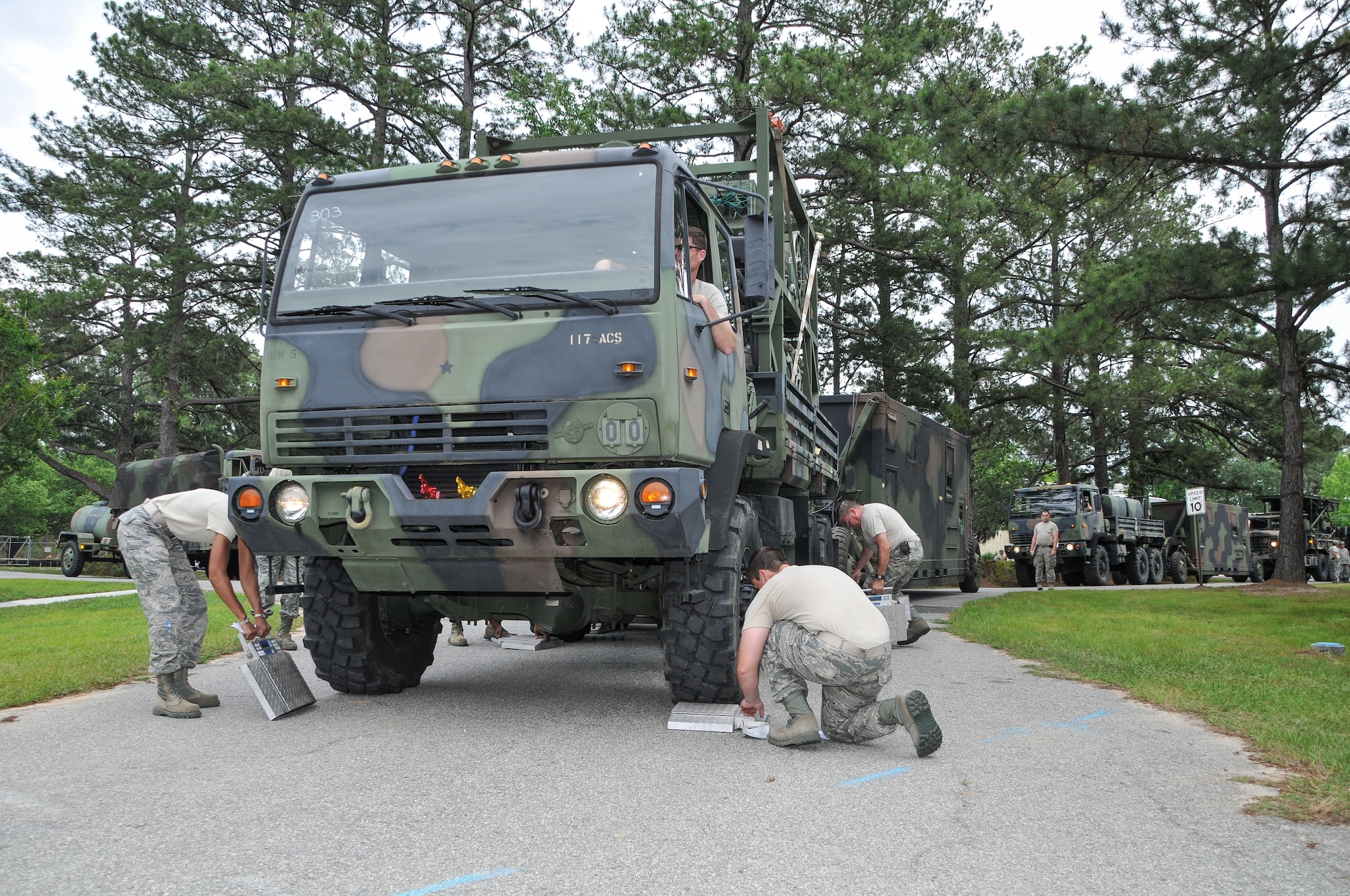 National Guard Master Sgt. Shane Shaw drives a truck on to scales at Hunter Army Airfield in Savannah, GA, April 21, 2012. Two trucks were used to position rolling equipment during the main site setup of the annual field training. (National Guard photo by Tech. Sgt. Charles Delano/Released)