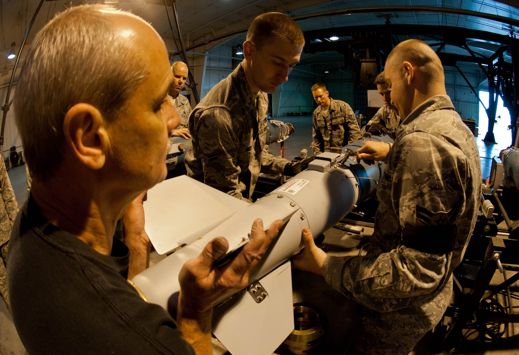 Mike Raybon, Joint Direct Attack Munition specialist from Eglin Air Force Base, Fla, assists 28th Munitions Squadron conventional maintenance members with attaching a tail fin onto a GBU-54 as part of a training exercise on Ellsworth Air Force Base, S.D., April 18, 2012. The tail fin stabilizes the GBU-54 to precisely guide it to its target. (U.S. Air Force photo by Airman 1st Class Zachary Hada/Released)
