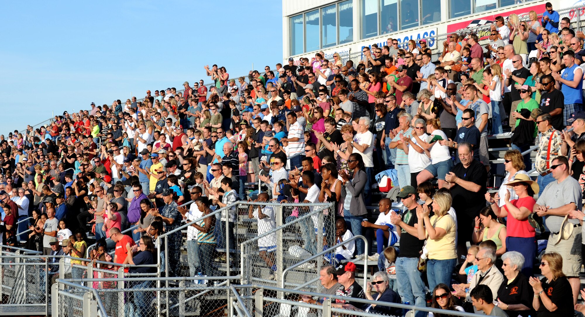 The crowd applauds U.S. Coast Guard Lt. Michelle Schopp for her performance of the national anthem at Langley Motor Speedway in Hampton Va. for Military Appreciation Night May 19. Military members and dependents were allowed free entry to the races for the evening. (U.S. Air Force photo by Airman 1st Class Austin Harvill/Released) 