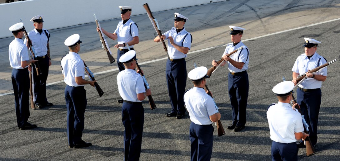 The U.S. Coast Guard Training Center Yorktown silent drill team performs at the Langley Motor Speedway in Hampton, Va. during Military Appreciation Night May 19. The drill team was the first military performance of the night, followed by a joint-service color guard. (U.S. Air Force photo by Airman 1st Class Austin Harvill/Released) 
