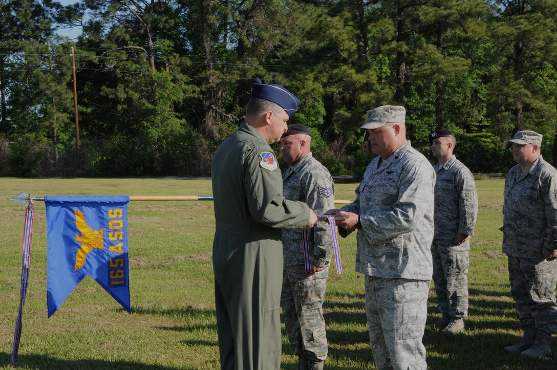 National Guard Maj. Gen. Jim Butterworth, Adjutant General, Georgia National Guard, presents National Guard Lt. Col. Timothy King, 165th Air Support Operation Squadron Commander, with the Air Force Outstanding Unit Award ribbon and plaque during an award ceremony at Savannah/Hilton Head International Airport in Savannah, Ga., April 14, 2012. National Guardsmen from the 165th ASOS, distinguished themselves by providing Terminal Attack Control of over 700 Close Air Support sorties while being deployed worldwide from August 9, 2009 through August 2, 2011. (National Guard photo by Staff Sgt. Noel Velez/released)