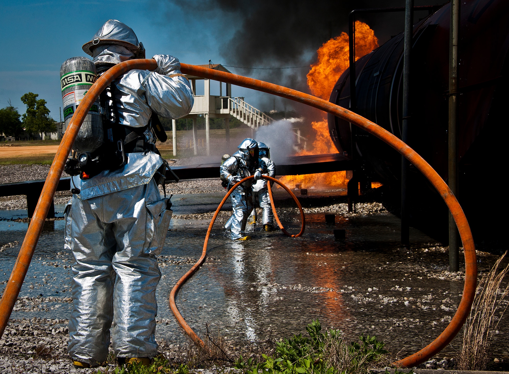 Firefighters move toward the front of the aircraft during a live-fire exercise at Eglin Air Force Base, Fla.  The aircraft fire training is a yearly requirement for Eglin’s Airmen and civilian firefighters.  The firefighters must battle a fire on the inside and outside of the aircraft to complete the training.  (U.S. Air Force photo/Samuel King Jr.)
