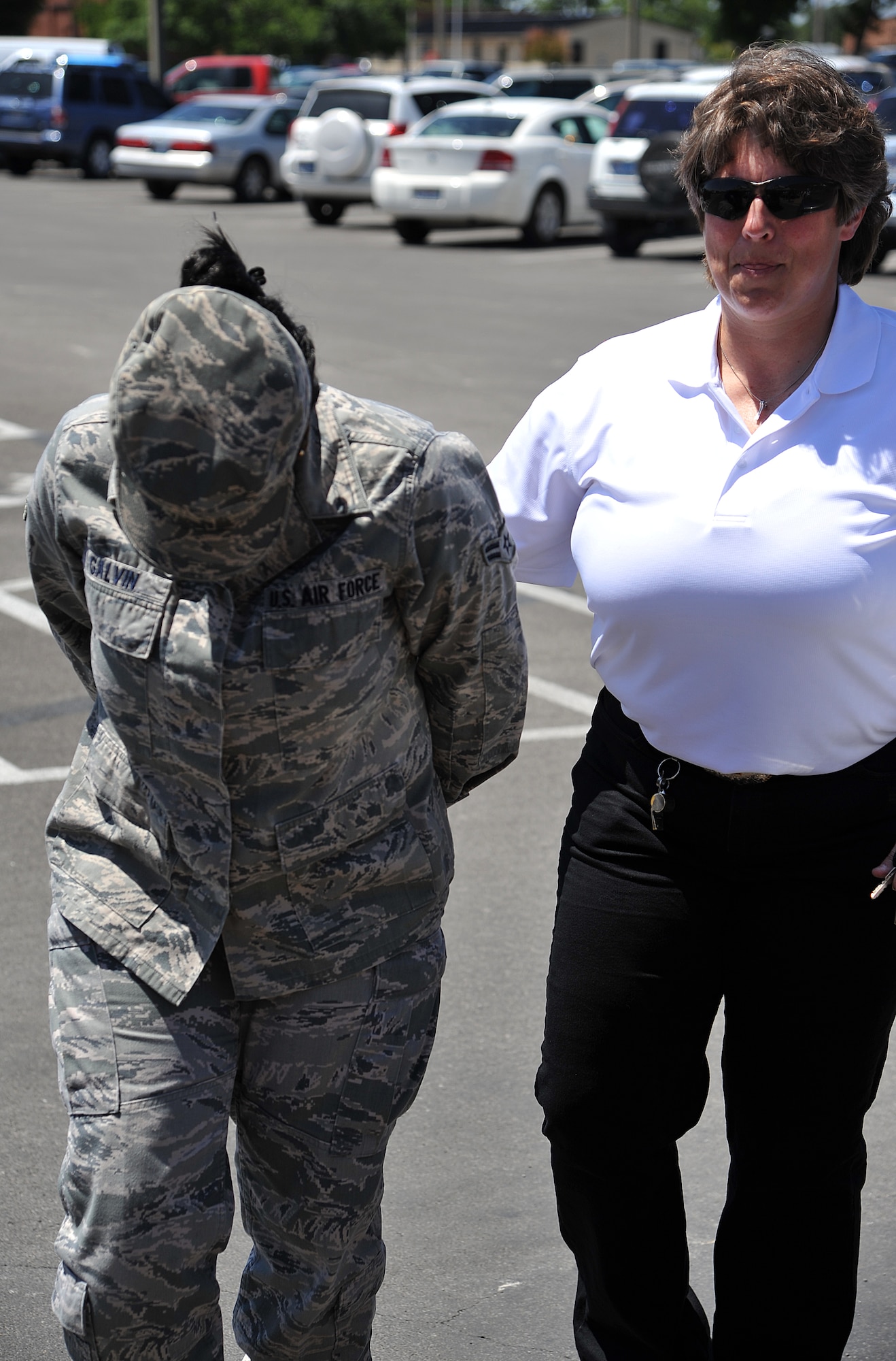GOODFELLOW AIR FORCE BASE, Texas-- Airman 1st Class Lashea Galvin, 17th Force Support Squadron, holds her head down in shame after being arrested during the Jail-N-Bail fundraiser set up by 17th Security Forces Squadron May 17.Team Goodfellow members had the ability to put each other in the simulated jail cell during National Police Week for up to an hour. (U.S. Air Force photo/ Airman 1st Class Michael Smith)