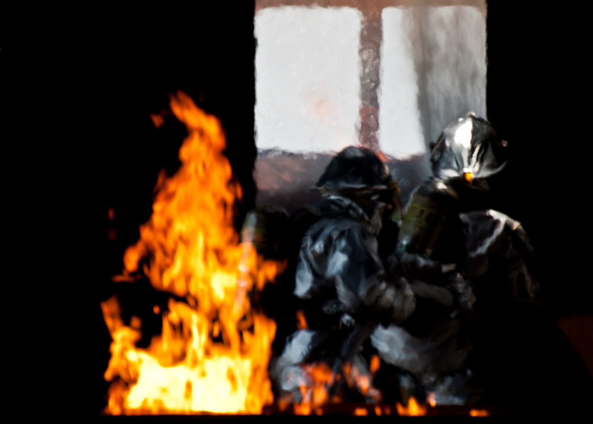 A two-man team of firefighters battle a blaze in the cockpit as another fire burns in the tail section of the aircraft during a live-fire exercise at Eglin Air Force Base, Fla.  The aircraft fire training is a yearly requirement for Eglin’s Airmen and civilian firefighters.  The firefighters must battle a fire on the inside and outside of the aircraft to complete the training.  (U.S. Air Force photo/Samuel King Jr.)