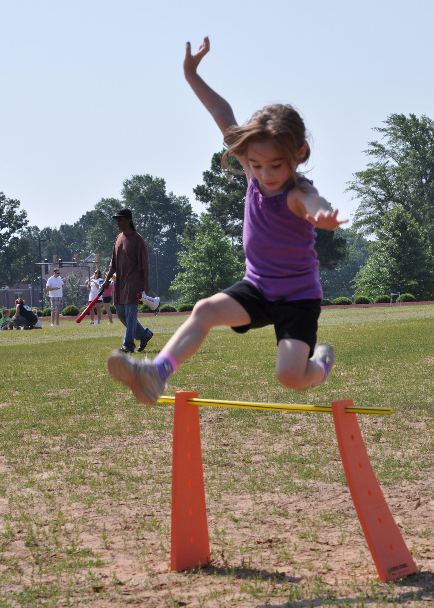 Paige Shuss, daughter of a Team Little Rock member, leaps a hurdle during kid's Field Day at the Warfit Track May 19, 2012, at Little Rock Air Force Base, Ark. Field Day gave children from all over the base a chance to play outside, and had specific stations adapted for exceptional family members. (U.S. Air Force photo by Staff Sgt. Jacob Barreiro)
