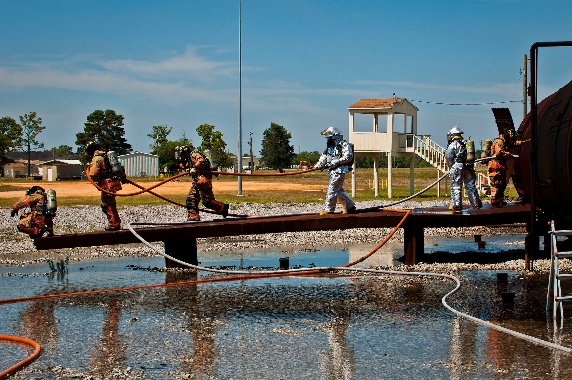 A team of firefighters exit the aircraft from the wing after battling fires in the cockpit and tail sections of the plane as part of a live-fire exercise at Eglin Air Force Base, Fla.  The aircraft fire training is a yearly requirement for Eglin’s Airmen and civilian firefighters.  The firefighters must battle a fire on the inside and outside of the aircraft to complete the training.  (U.S. Air Force photo/Samuel King Jr.)