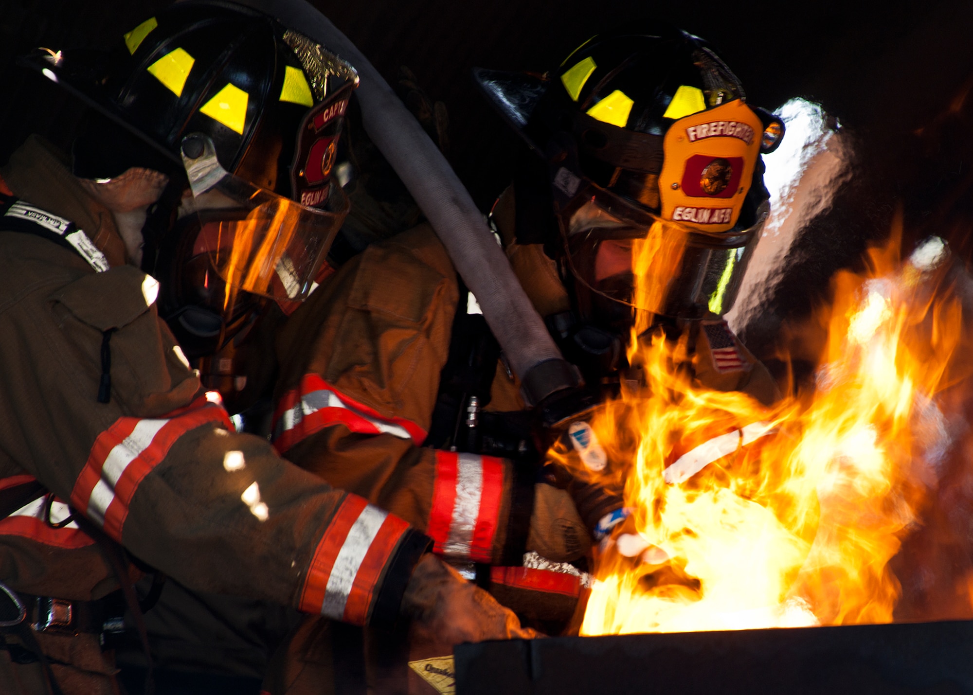 Airman Brentley Kilpatrick, a 96th Civil Engineer Squadron firefighter, and his teammate battle a blaze inside the aircraft during a live-fire exercise at Eglin Air Force Base, Fla.  The aircraft fire training is a yearly requirement for Eglin’s Airmen and civilian firefighters.  The firefighters must battle a fire on the inside and outside of the aircraft to complete the training.  (U.S. Air Force photo/Samuel King Jr.)