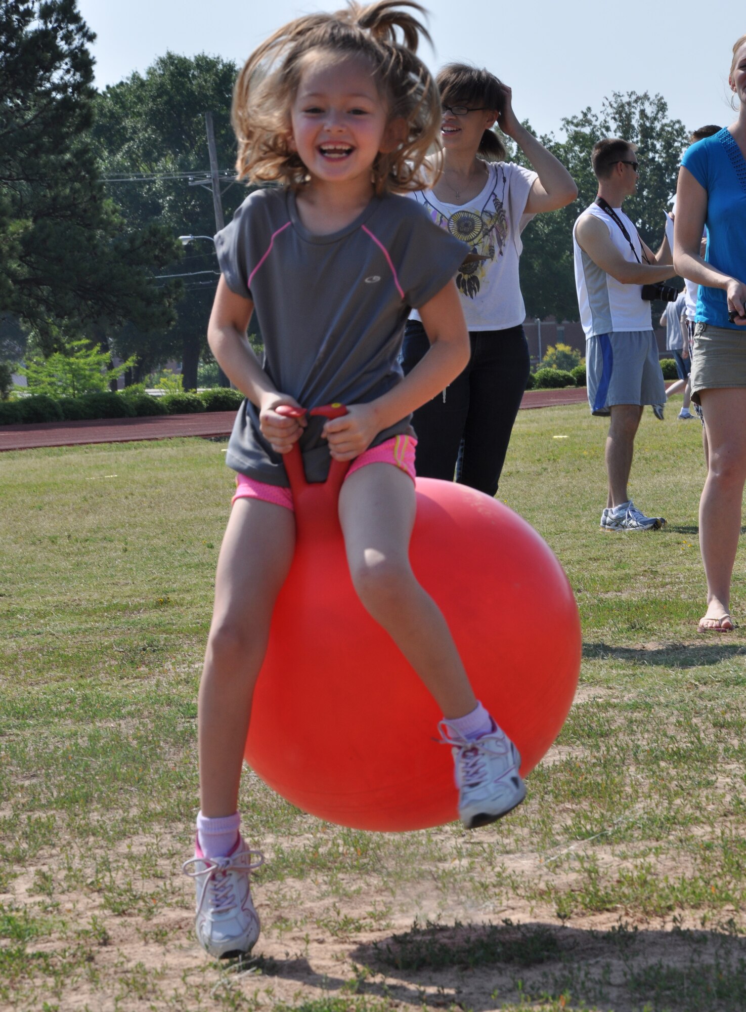 Cece Brown, 6, bounces on a ball during kid's Field Day at the Warfit Track May 19, 2012, at Little Rock Air Force Base, Ark. There were various stations for kids to play at during the field day, including a soccer kick, football throw, hurdles and softball toss. (U.S. Air Force photo by Staff. Sgt. Jacob Barreiro)