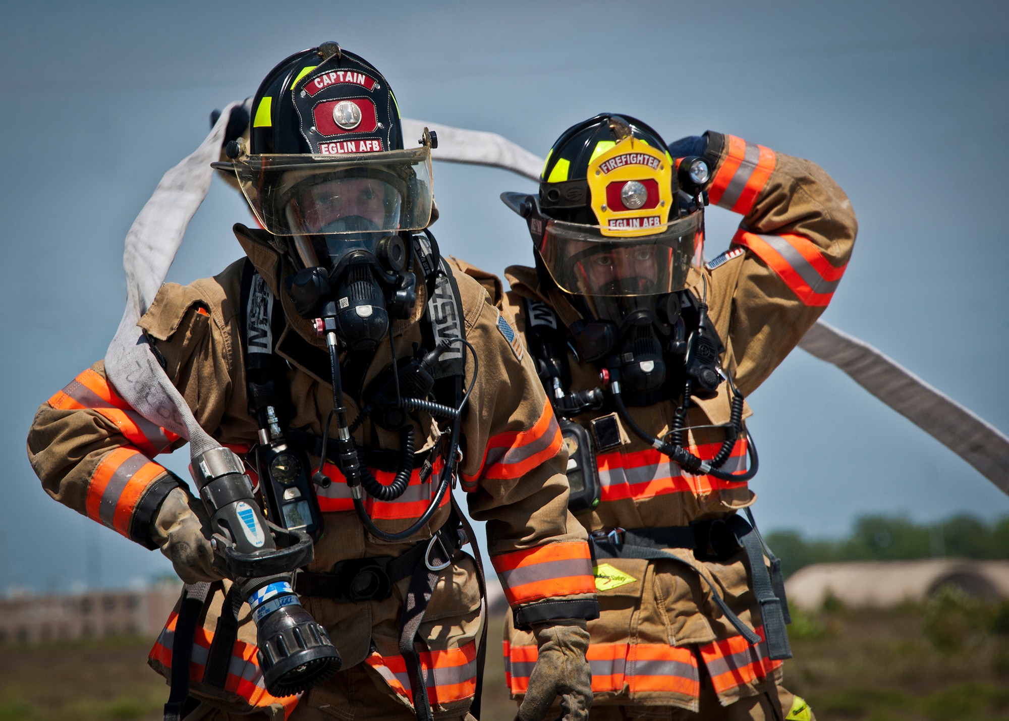 Firefighters move into position before approaching the burning aircraft during an aircraft fire exercise at Eglin Air Force Base, Fla.  The aircraft fire training is a yearly requirement for Eglin’s Airmen and civilian firefighters. The firefighters must battle a fire on the inside and outside of the aircraft to complete the training.   (U.S. Air Force photo/Samuel King Jr.)