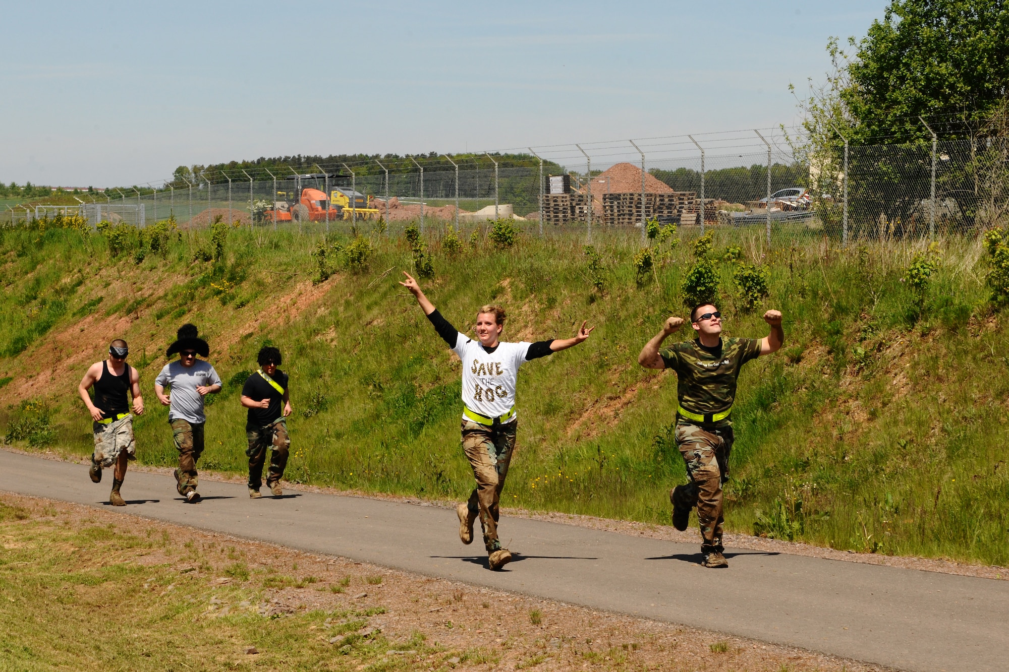 SPANGDAHLEM AIR BASE, Germany -- Team Action Figure Therapy members approach the finish line during the Tier II Mud-Run outside base here May 17. The mud-run consisted of 17 teams, which ran five kilometers through various obstacles and competed for best costumes. The event raised more than $2,000 for the Wounded Warrior Project in Landstuhl. (U.S. Air Force photo by Airman 1st Class Dillon Davis/Released)