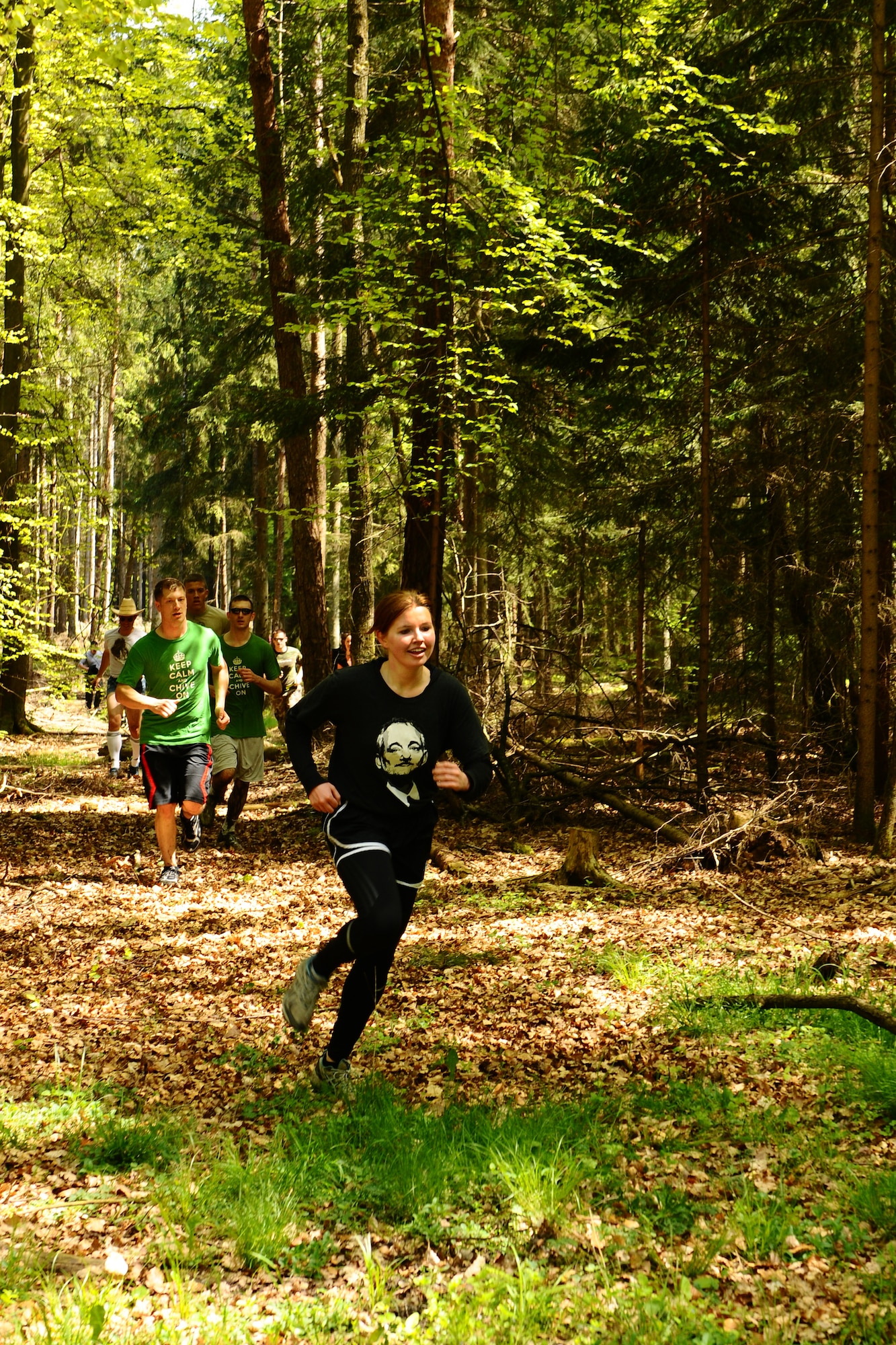 SPANGDAHLEM AIR BASE, Germany -- Team Chive On members run through the forest during the Tier II Mud-Run outside base here May 17. The mud-run consisted of 17 teams, which ran five kilometers through various obstacles and competed for best costumes. The event raised more than $2,000 for the Wounded Warrior Project in Landstuhl. (U.S. Air Force photo by Airman 1st Class Dillon Davis/Released)