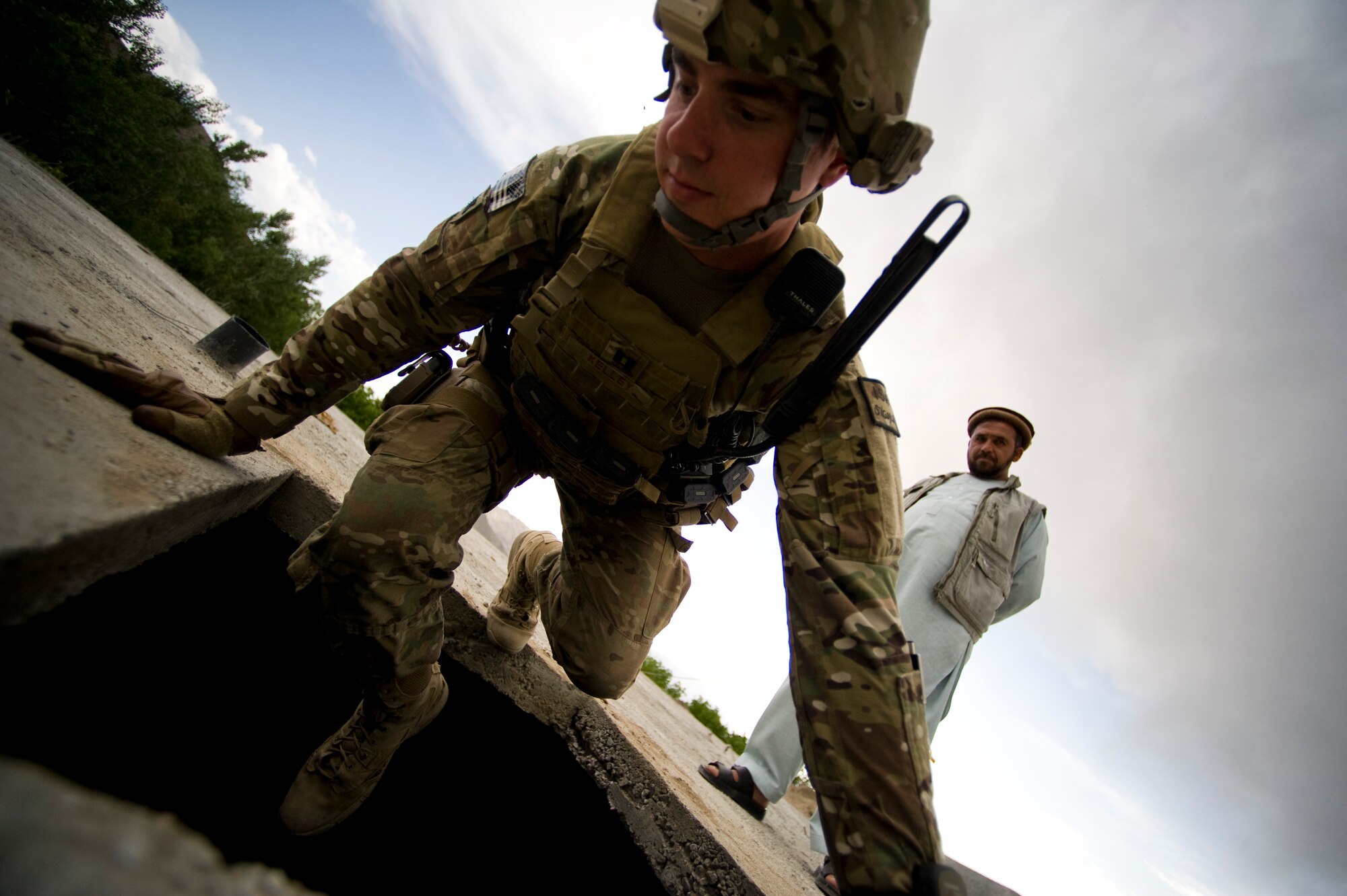 U.S. Air Force Capt. Scott Kelly with Provincial Reconstruction Team Kapisa climbs through an opening in the roof of a school while a local contractor watches him, Kapisa Province, May 17, 2012. The Kapisa PRT is a U.S. military team that engages with local leaders and contractors to plan and inspect development projects in the province. (U.S. Air Force photo by Staff Sgt. Greg C. Biondo)(Released)