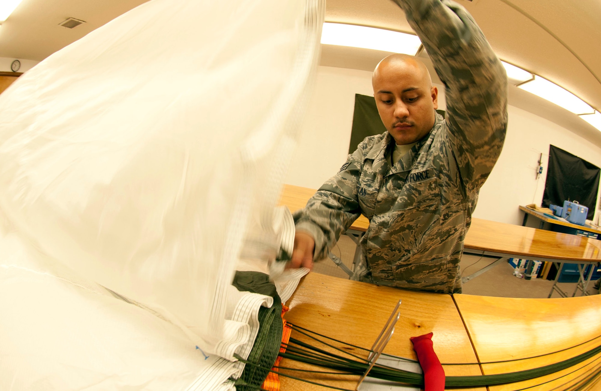 U.S. Air Force Staff Sgt. Edwin Portan, 379th Expeditionary Operations Support Squadron, airs the BA-22 parachute canopy to ensure the materials are not intertwined together prior to repacking during an inspection May 17, 2012. Portan is the Non-commissioned officer in-charge, Air Crew Flight Equipment and is deployed from Eglin Air Force Base, Fla. (U.S. Air Force photo/Staff Sgt. Sheila deVera)