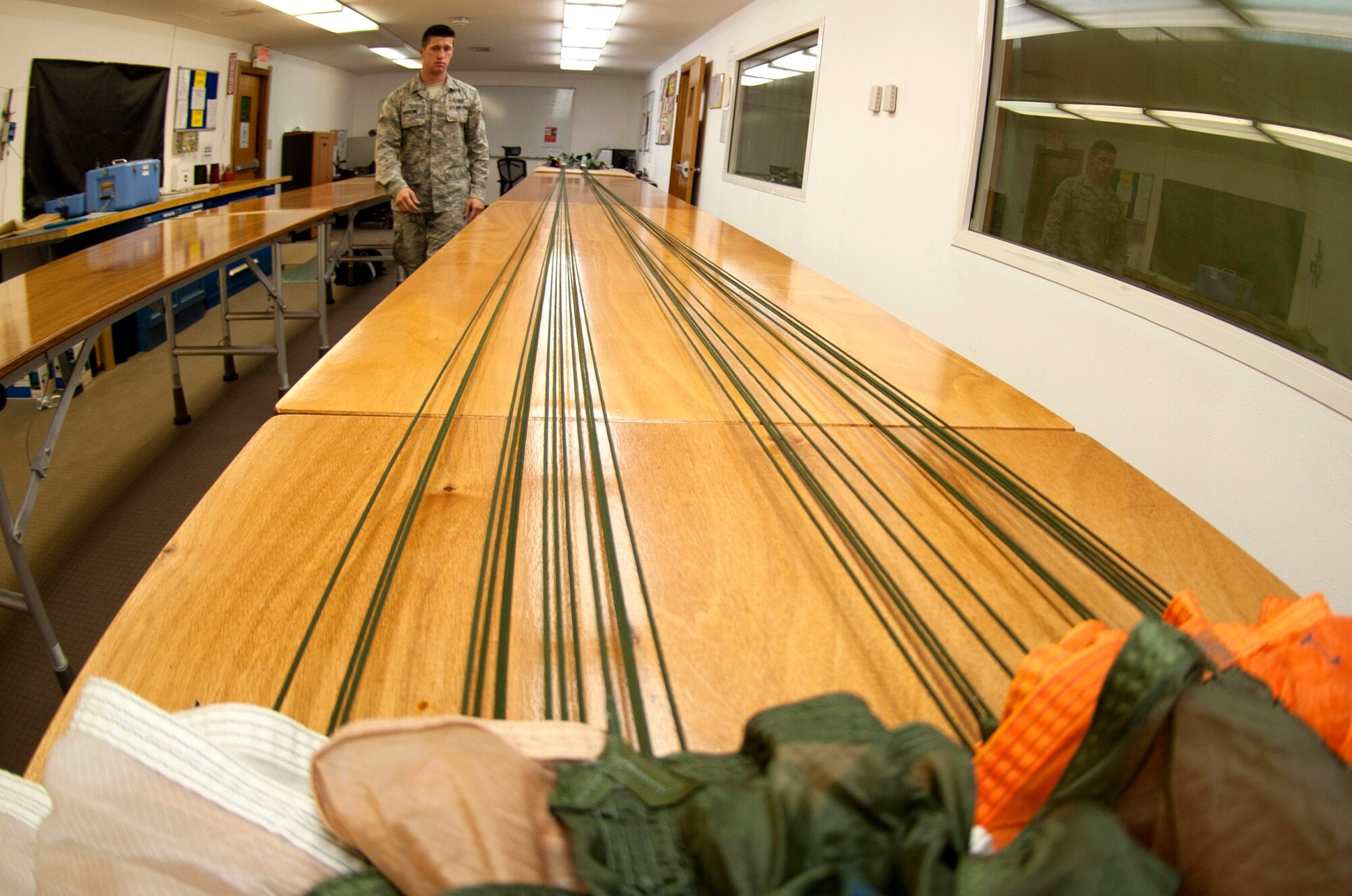 U.S. Airman 1st Class Michael Mauldin, 379th Expeditionary Operations Support Squadron aircrew flight equipment technician, visually inspects a BA-22 parachute during May 17, 2012. Mauldin conducts inspections regularly that take an average of three hours per parachute. (U.S. Air Force photo/Staff Sgt. Sheila deVera)