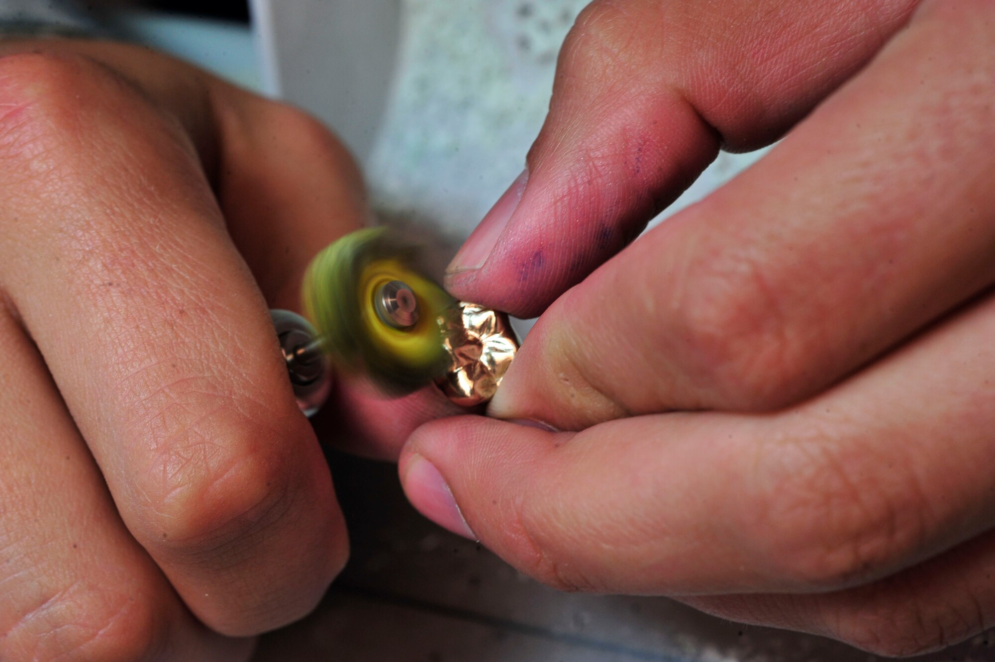 U.S. Air Force Senior Airman Justin Rhodes, 20th Dental Squadron dental lab technician, polishes a gold crown at Shaw Air Force Base, S.C., May 15, 2012.  Rhodes is a native of Owensboro, Ky.(U.S. Air Force photo by Airman Nicole Sikorski/Released) 
