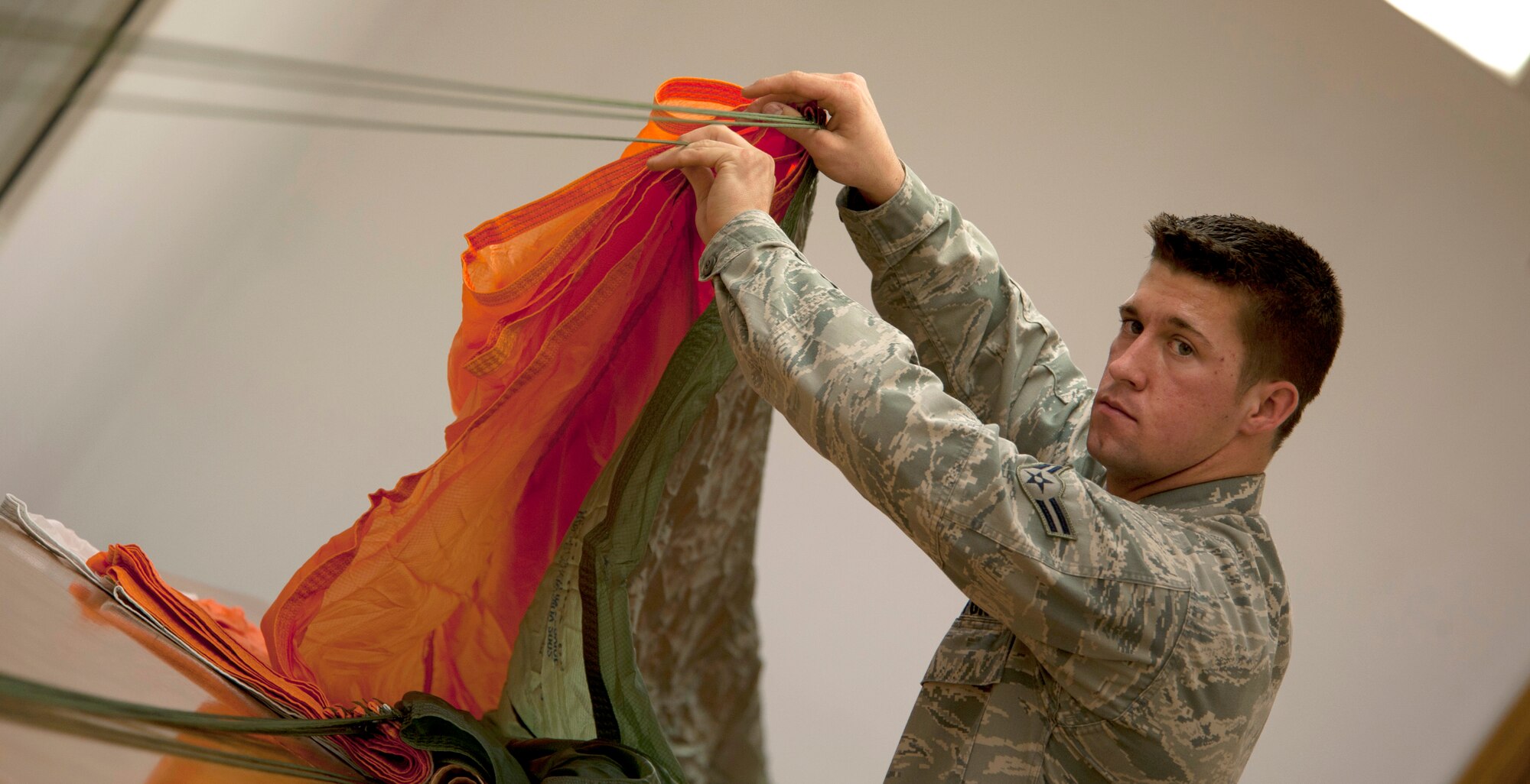 U.S. Airman 1st Class Michael Mauldin, 379th Expeditionary Operations Support Squadron aircrew flight equipment technician, inspects the suspension line May 17, 2012. The inspection recertifies the life cycle of the parachute and must be 100% serviceable at all times. Mauldin is deployed from Dyess Air Force Base, Texas. (U.S. Air Force photo/Staff Sgt. Sheila deVera)