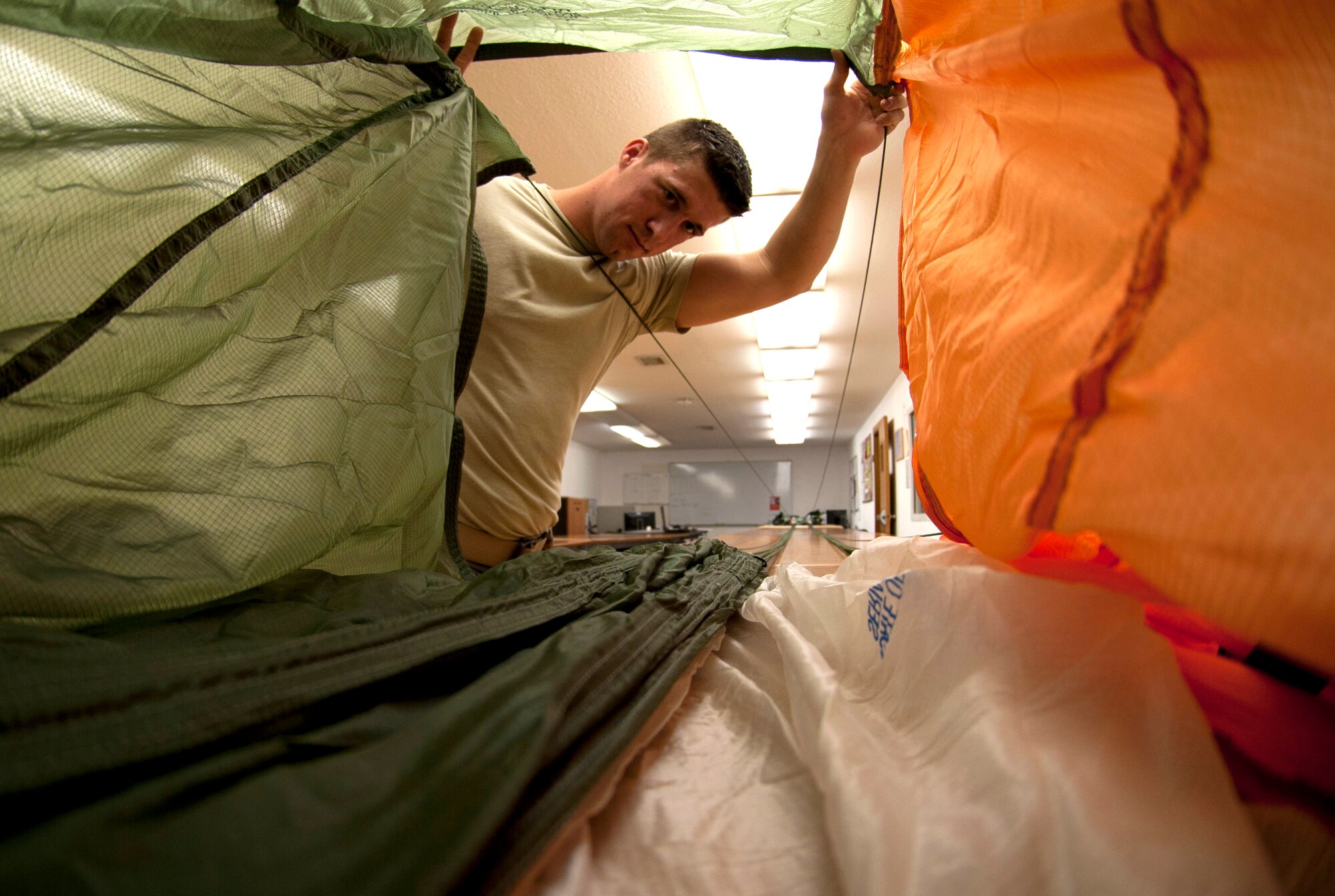 U.S. Airman 1st Class Michael Mauldin, 379th Expeditionary Operations Support Squadron aircrew flight equipment technician, inspects the air channel of a BA-22 parachute canopy after conducting an inspection May 17, 2012. The inspection recertifies the life cycle of the parachute and must be 100% serviceable at all times. Mauldin is deployed from Dyess Air Force Base, Texas. (U.S. Air Force photo/Staff Sgt. Sheila deVera)