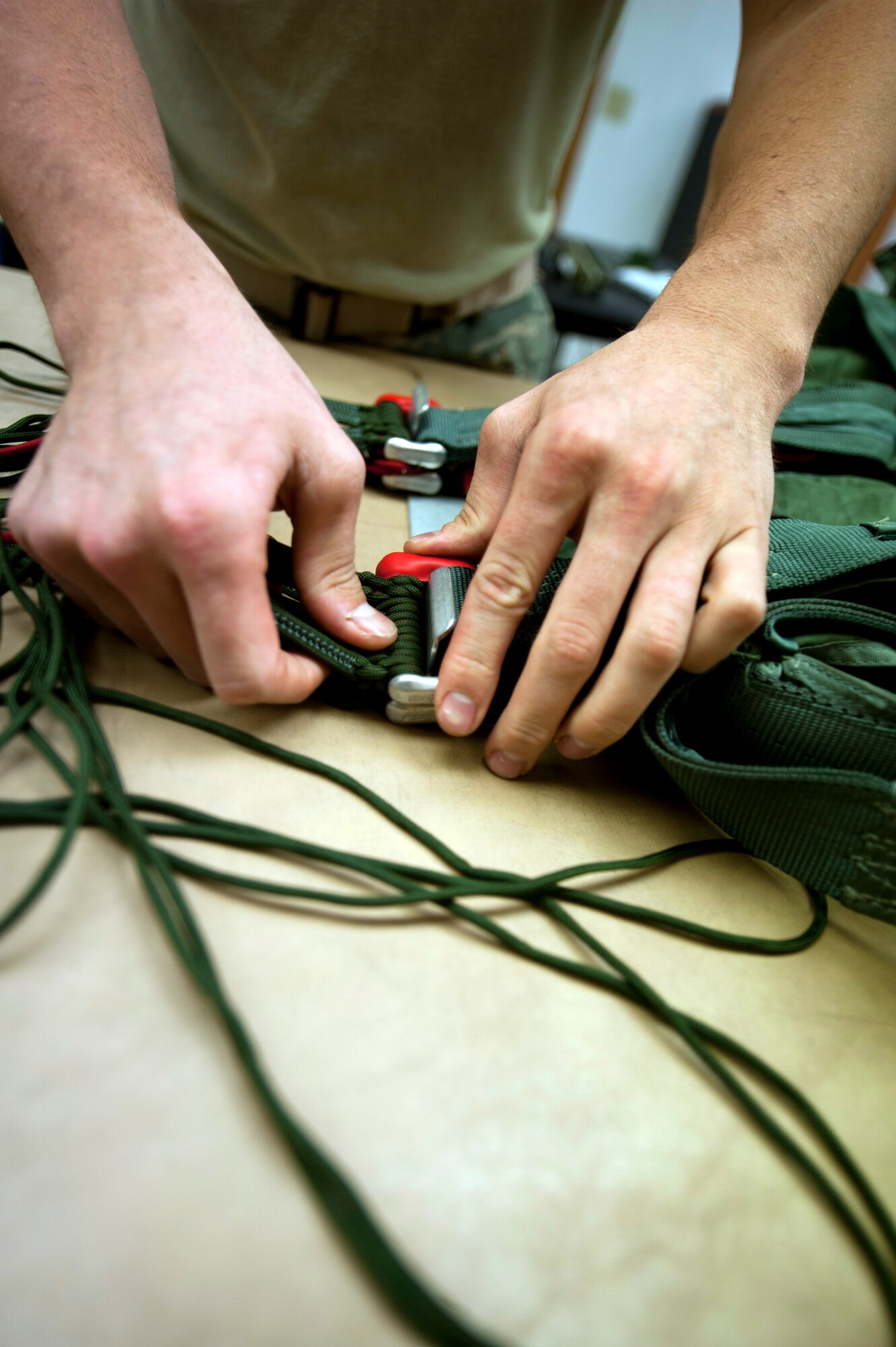 U.S. Airman 1st Class Michael Mauldin, 379th Expeditionary Operations Support Squadron aircrew flight equipment technician, inspects the connector links and 4-line modification of a BA-22 parachute during an inspection May 17, 2012. The inspection recertifies the life cycle of the parachute and must be 100% serviceable at all times. Mauldin is deployed from Dyess Air Force Base, Texas. (U.S. Air Force photo/Staff Sgt. Sheila deVera)