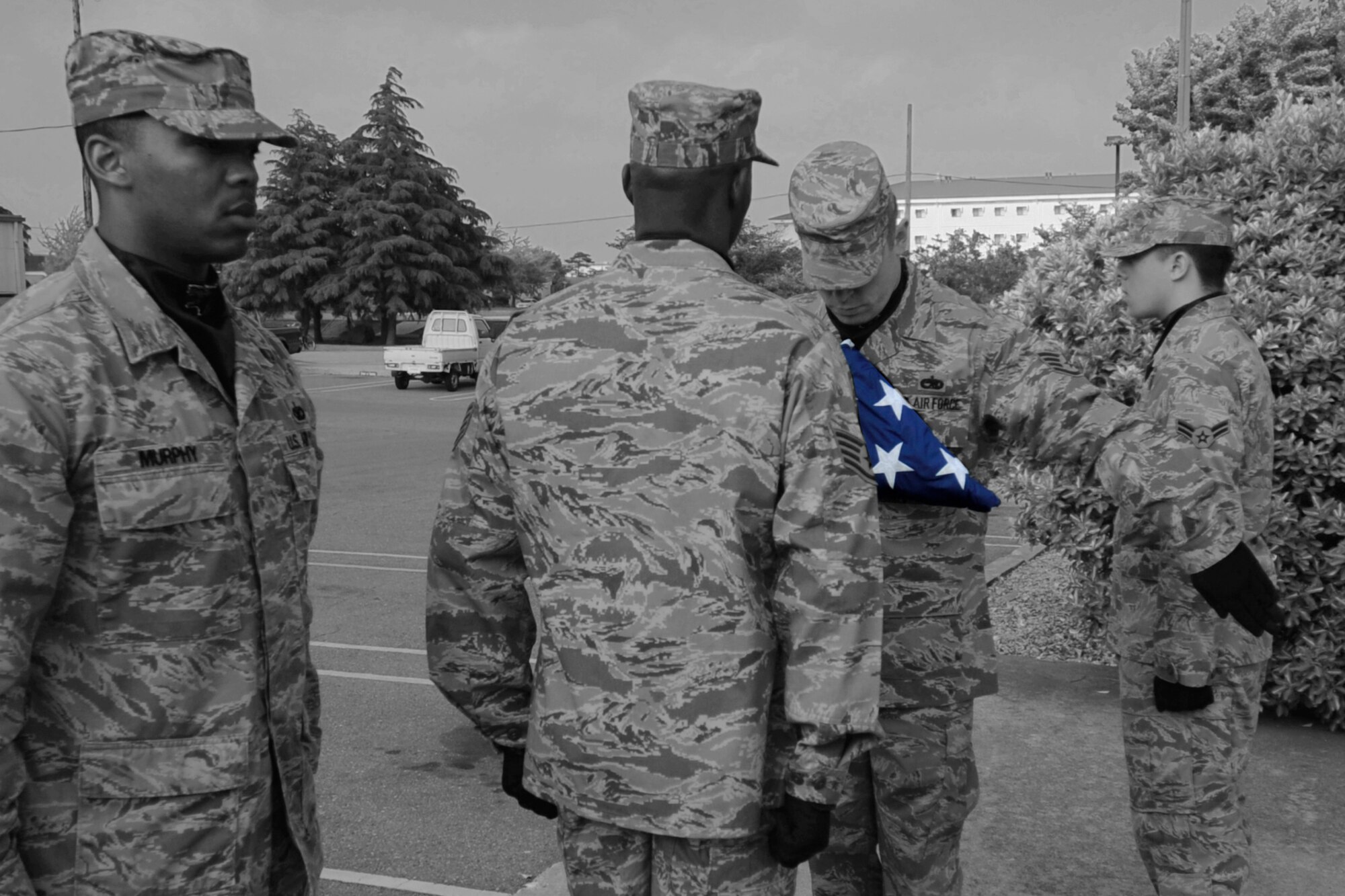 Members of the Kunsan Air Base Honor Guard stand at attention as another member ensures the United States flag is properly folded during a retreat ceremony May 18, 2012 on Kunsan Air Base, Republic of Korea. (U.S. Air Force illustration/ Senior Airman Jessica Hines)