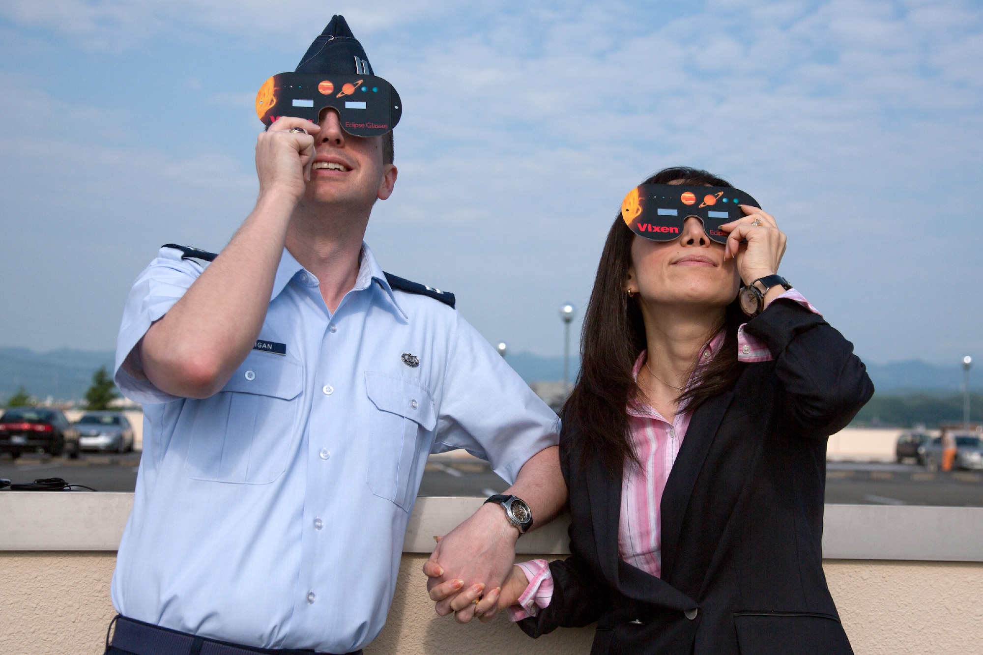 YOKOTA AIR BASE, Japan -- Capt. Drew Jernigan, 374th Airlift Wing legal office, and his wife Makiko enjoy watching the annular solar eclipse at Yokota Air Base, Japan, May 21, 2012. The annular solar eclipse, takes place when the moon covers as much as 94 percent of the sun resulting in a "ring of fire". (U.S. Air Force photo by Osakabe Yasuo)