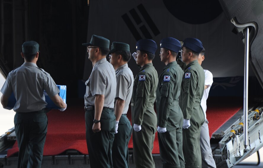 The remains of a Korean War unknown are brought aboard an awaiting Republic of Korea transport aircraft by a representative from the Republic of Korea and the Ministry of National Defense for Killed in Action Recovery and Identification during a Repatriation Ceremony hosted by the U.S. Joint POW/MIA Accounting Command May 22 at Joint Base Pearl Harbor Hickam, Hawaii. A total of 12 sets of remains of Korean War unknowns, which were determined to not be U.S. service members by JPAC's Central Identification Laboratory, were transferred custody for further analysis. This is the second time in the past approximately 10 years JPAC has repatriated remains to South Korea. (U.S. Air Force photo by Captain Ben Sakrisson)
