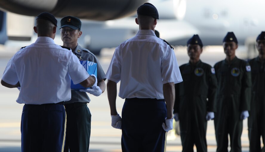 The remains of a Korean War unknown are passed from a U.S. service member representing the U.S. Joint POW/MIA Accounting Command to a representative from the Republic of Korea and the Ministry of National Defense for Killed in Action Recovery and Identification during a Repatriation Ceremony May 22 at Joint Base Pearl Harbor Hickam, Hawaii. A total of 12 sets of remains of Korean War unknowns, which were determined to not be U.S. service members by JPAC's Central Identification Laboratory, were transferred custody for further analysis. This is the second time in the past approximately 10 years JPAC has repatriated remains to South Korea. (U.S. Air Force photo by Captain Ben Sakrisson)
