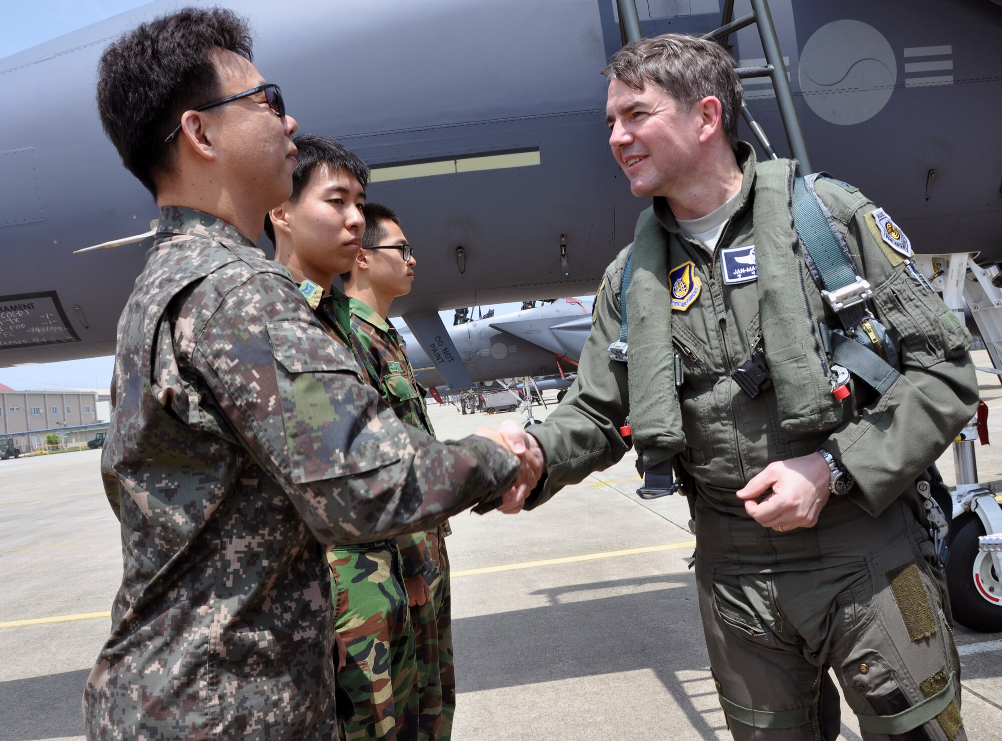 Lt. Gen. Jan-Marc Jouas, 7th Air Force commander, coins members of the Republic of Korea Air Force after his flight in an F-15K Slam Eagle at Gwangju Air Base, May 15, 2012. Before his flight, ROK and U.S. crews provided a flight-support gear fitting, flight briefing, and preflight checks to the general. Jouas’ 2-hour flight was during combined exercise Max Thunder. (U.S Air Force photo/Airman 1st Class Michael Battles)