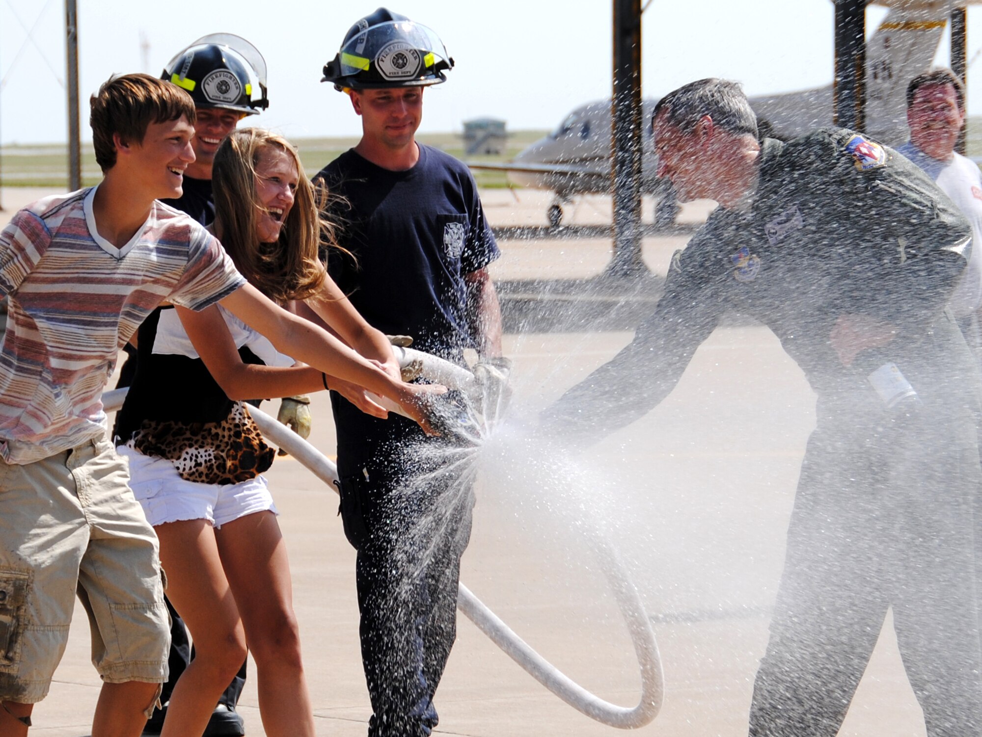 Col. Kurt Meidel, right, the 71st Operations Group commander at Vance Air Force Base, Okla., is sprayed down after his fini flight May 22 by his son, Luke, and daughter, Kaitlyn, with a little help from members of the Vance Fire Department. Meidel flew his last sortie as the 71st OG commander in a T-1A Jayhawk assigned to the 32nd Flying Training Squadron. Meidel will relinquish command of the Operations Group during a ceremony June 8 in Hangar 199. (U.S. Air Force photo/ Joe B. Wiles) 