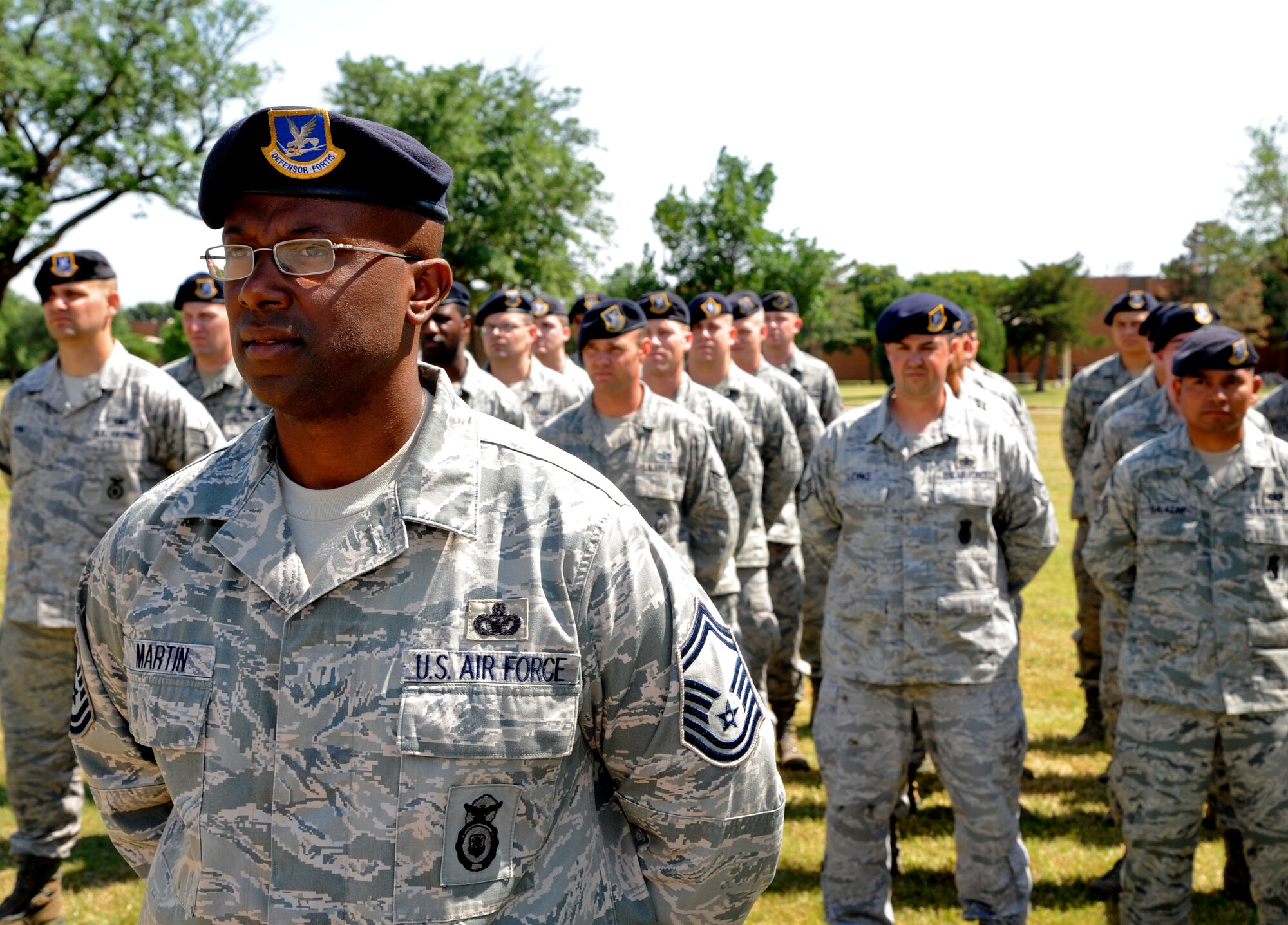 The 71st Security Forces Squadron ended a week-long celebration of National Police Week with a retreat ceremony Friday, May 18, at the flag pole at Vance Air Force Base, Okla. Senior Master Sgt. Torrance Martin, foreground, the 71st SFS operations superintendent, stands at parade rest with his Airmen during the ceremony. Events held throughout the week included a 20-mile torch run through the Enid, Okla., community, a candle-light vigil in the base Chapel and a Cops-for-Kids day display of equipment and security personnel. National Police Week was started by President John F. Kennedy in 1962 when he signed a proclamation designating May 15 as Peace Officers Memorial Day and the week in which it falls as Police Week. (U.S. Air Force photo/ Airman 1st Class Frank Casciotta)