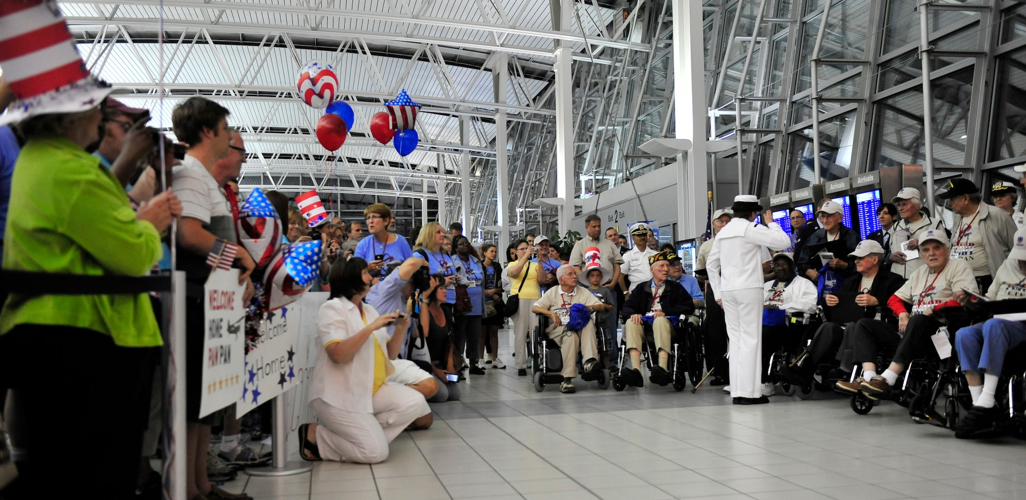 World War II veterans are presented a group photograph and letter of appreciation by active duty members assigned to Scott Air Force Base Ill., after their trip to the memorials in Washington D.C. May 21 sponsored by the Greater St Louis Honor Flight program.  Their family members and friends were waiting watching and cheering for them in the audience.  (U.S. Air Force photograph/ Staff Sgt. Stephenie Wade)