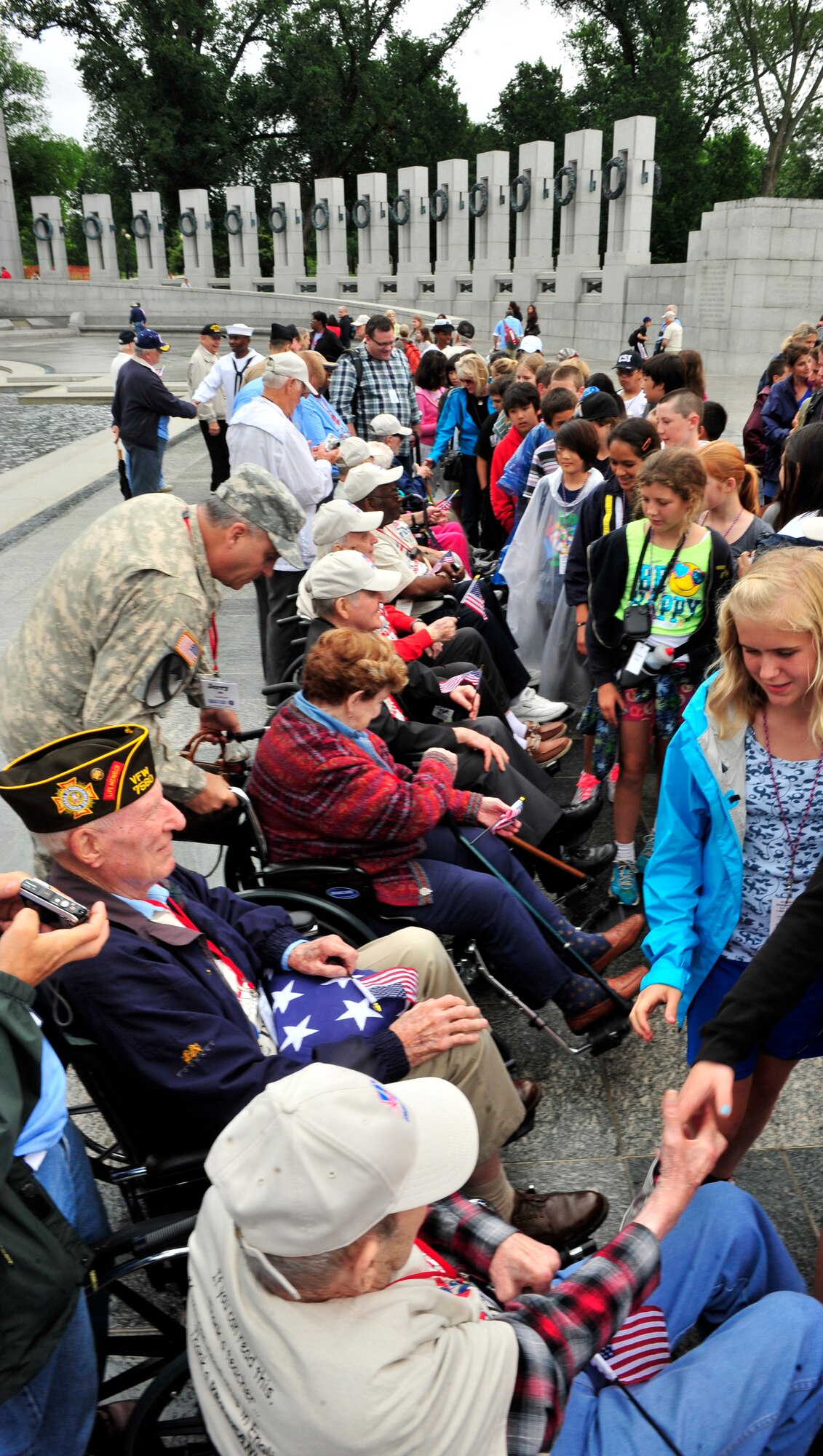 Middle School Students greet World War II veterans by shaking their hands and presenting them a small American flag outside the WWII memorial in Washington D.C. The trip is part of a program called the Greater St. Louis Honor Flight, a non-profit that takes World War II veteran to the to the memorials.  The WWII memorial honors the 16 million who served in the armed forces of the U.S. during World War II, the more than 400,000 who died, and the millions who supported the war effort from home. Symbolic of the defining event of the 20th Century, the memorial is a monument to the spirit, sacrifice, and commitment of the American people to the common defense of the nation and to the broader causes of peace and freedom from tyranny throughout the world. The memorial opened to the public on April 29, 2004 (U.S. Air Force photograph/ Staff Sgt. Stephenie Wade)