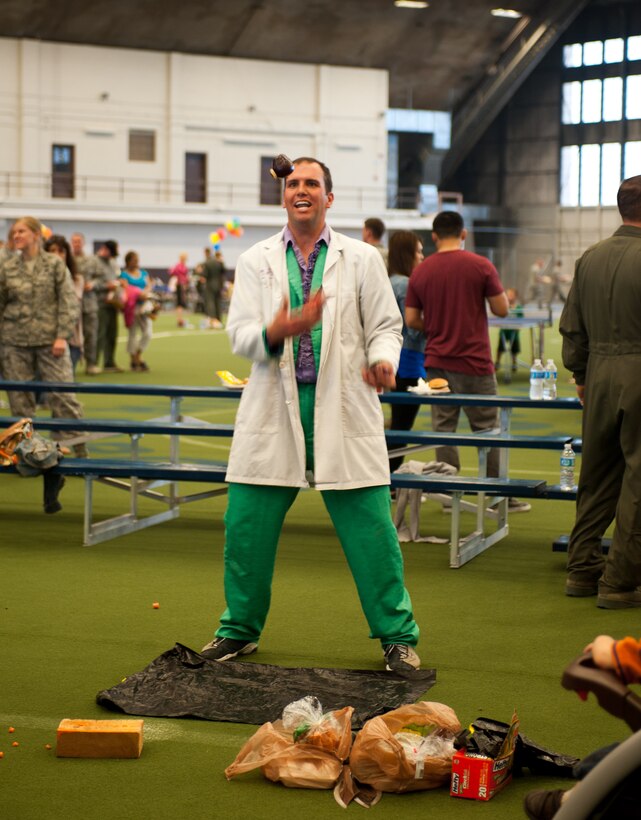 Capt. Bradley Harrelson, 28th Medical Operations Squadron dentist, also known as Dr. Juggles, tosses apples around during the 70th Anniversary Kick-Off Party at Ellsworth Air Force Base, S.D., May 18, 2012. Airmen and their families were invited to the Pride Hangar to enjoy a free meal, entertainment for children, tournaments, and prize drawings to kick off the weekend of the 70th Anniversary Celebrations. (U.S. Air Force photo by Airman 1st Class Alystria Maurer/Released)
